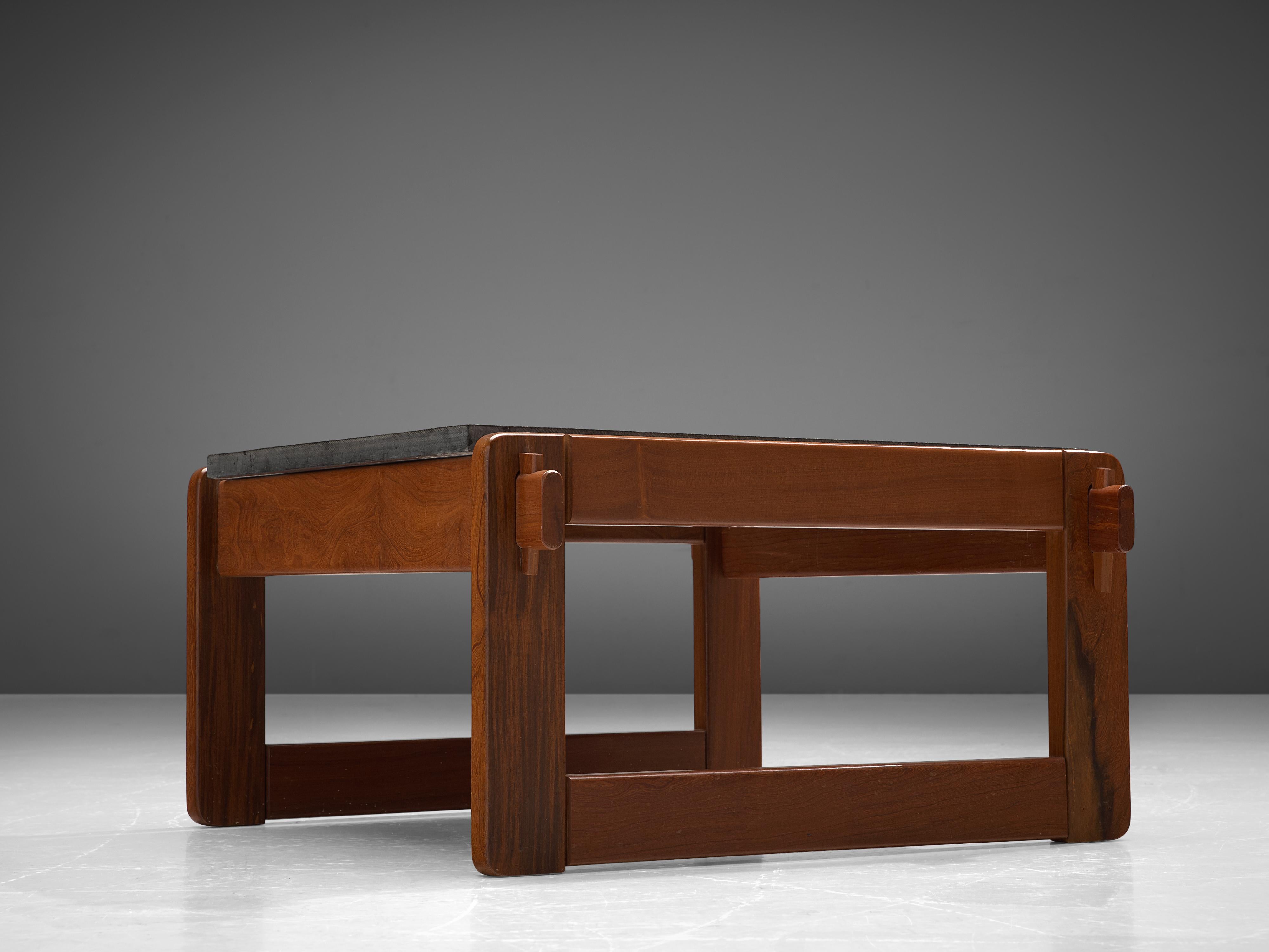Percival Lafer, coffee or side table, slate, wood, Brazil, 1970s.

This robust and notable coffee table with a dark tabletop in slate is designed by Percival Lafer. The tables consists of a thick wooden frame of which the wooden joints are clearly