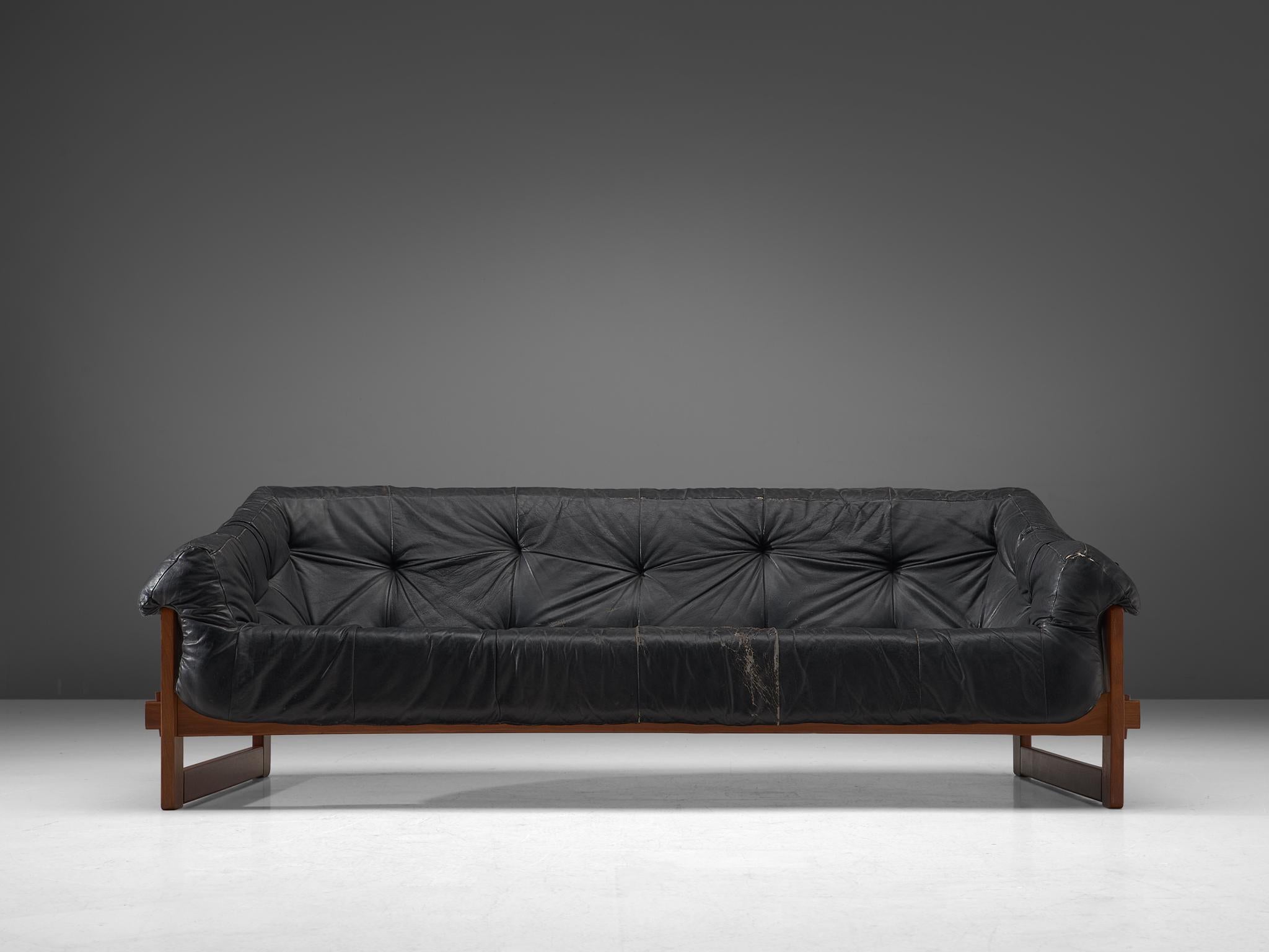 Percival Lafer, sofa, leather and brazilian hardwood, Brazil, late 1960s.

Bulky and grand sofa by Brazilian designer Percival Lafer. This set features a solid dark wooden base with leather straps spanned between the slats. The tufted leather