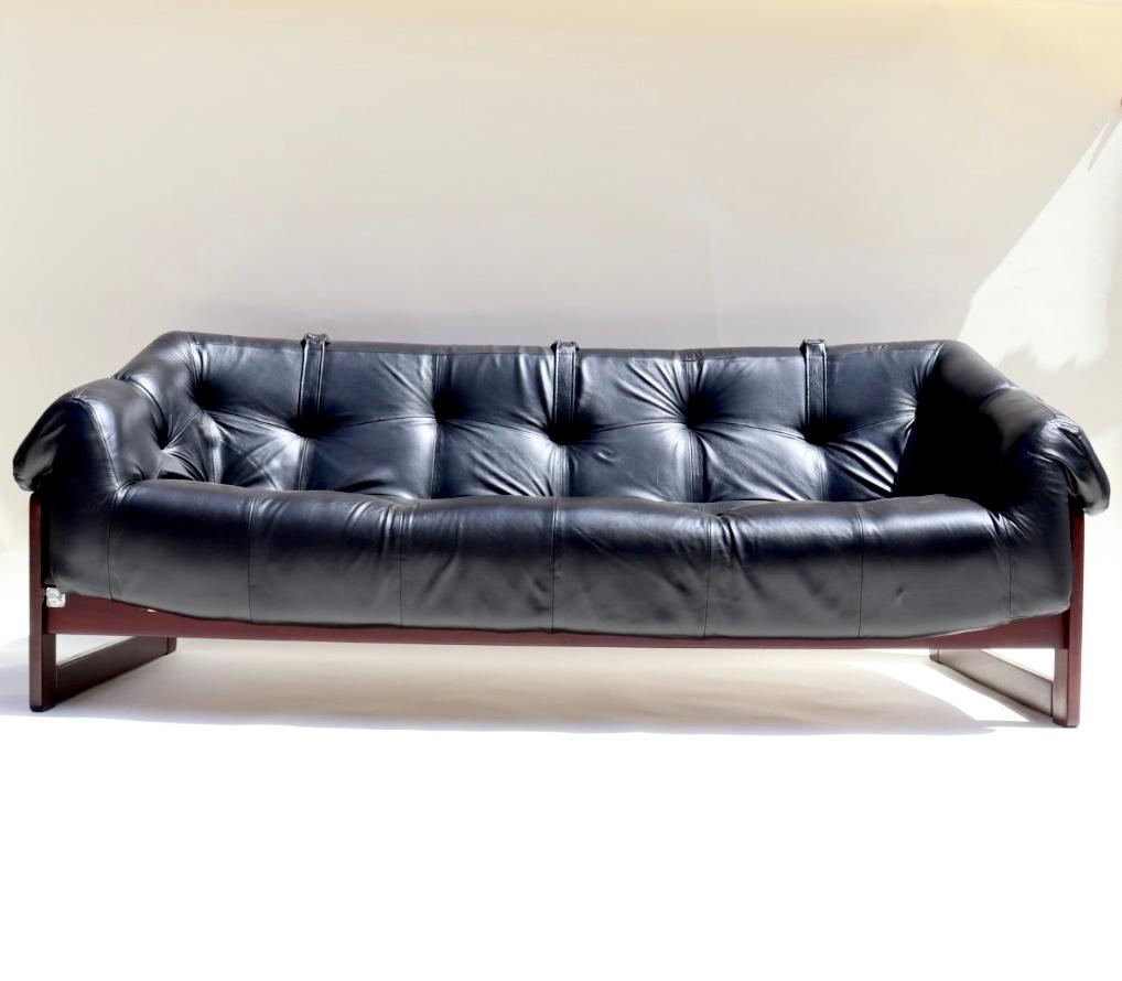 Percival Lafer MP-91 with solid rosewood frame with its plush black leather envelops you like a giant cloud. The black leather upholstery is suspended via leather straps and wood dowels that pull through the solid rosewood frame. This sofa is the