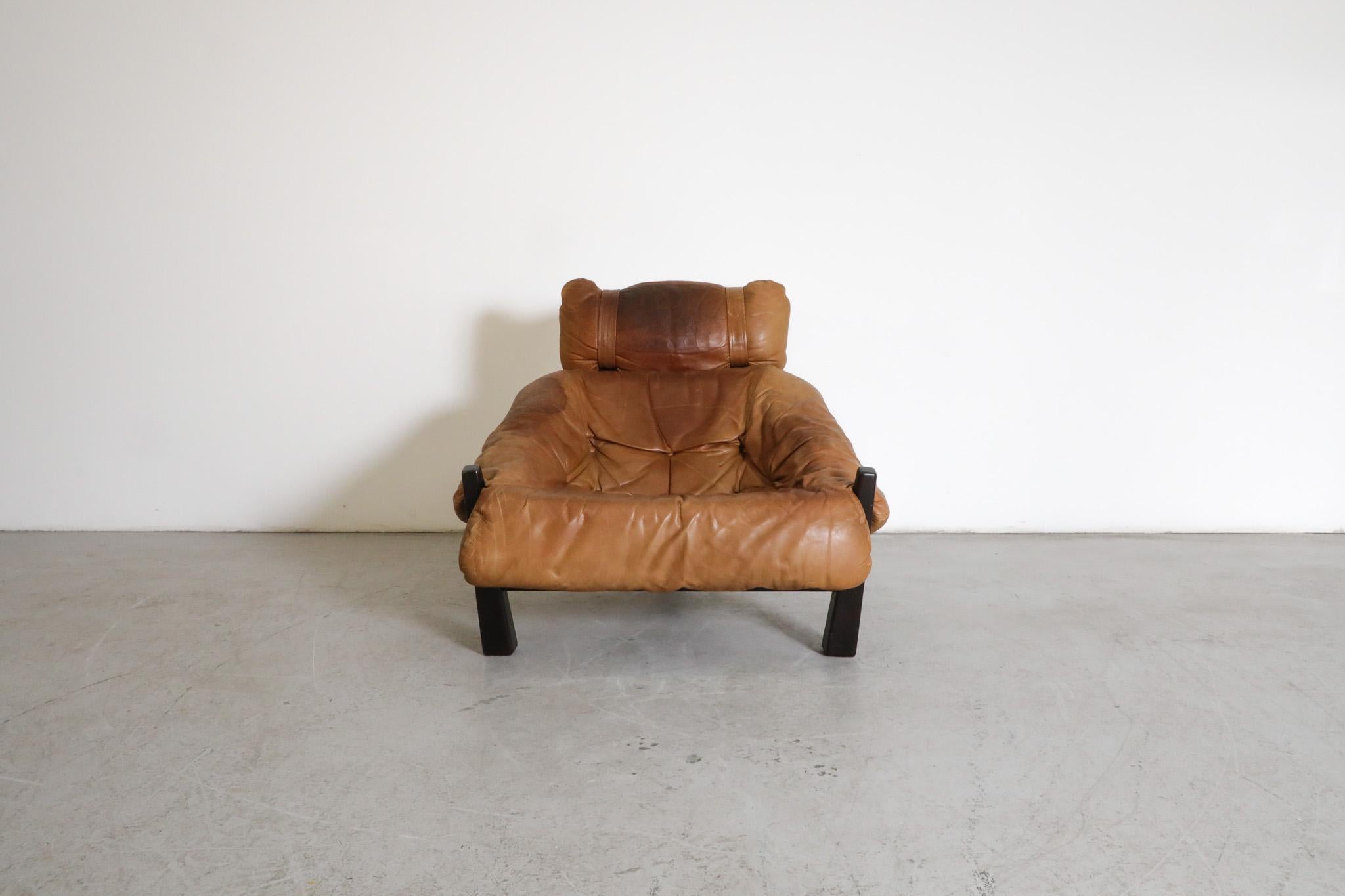 Mid-Century leather lounge chair designed by Gerard Van Den Berg for Montis. Dark stained oak frame with tripod legs supports the leather bucket seat cushion and headrest. In original condition with heavy visible wear consistent with its age and