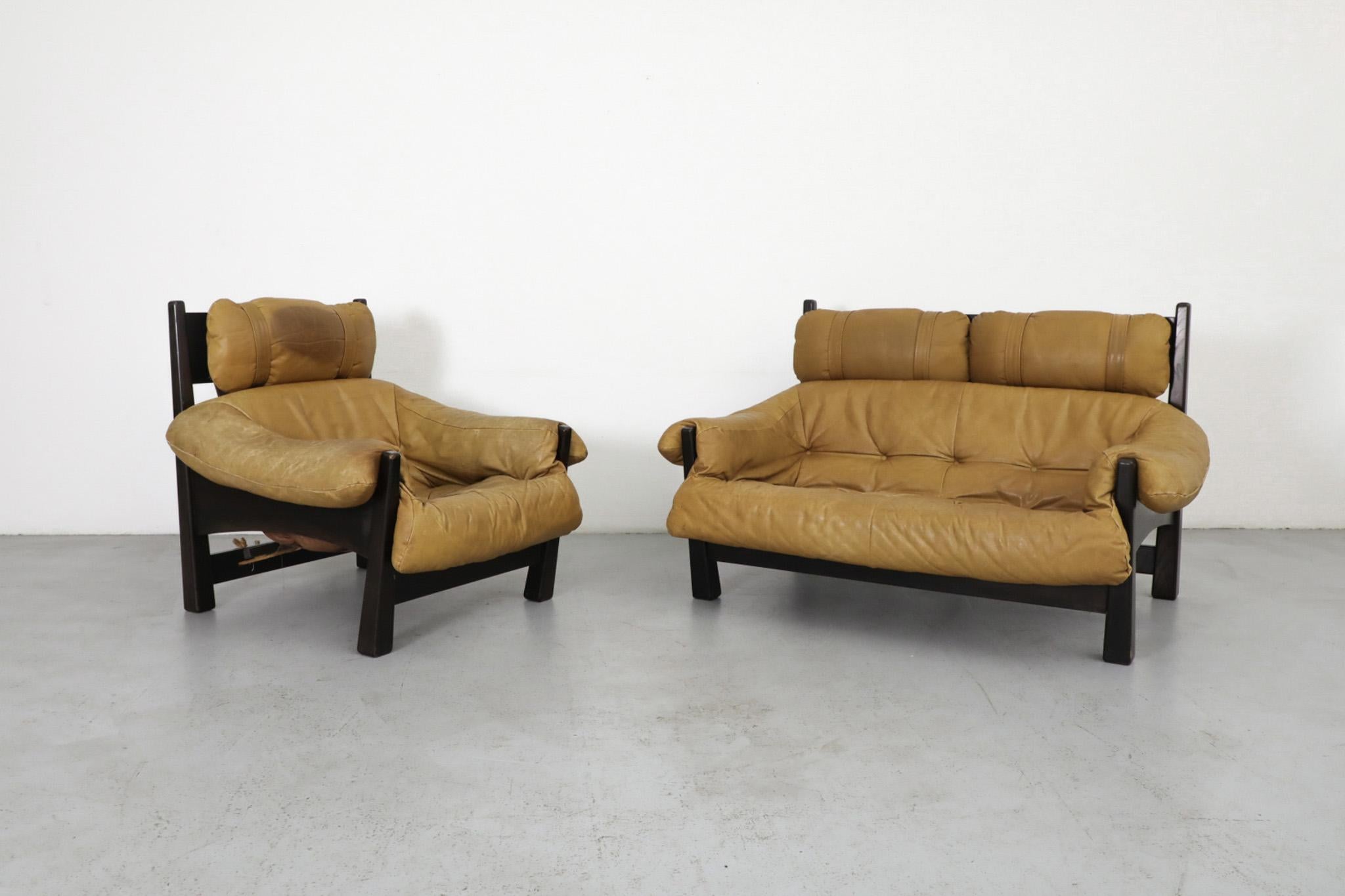 Mid-Century leather sofa designed by Gerard van den Berg for Montis. Dark stained oak frame with tripod legs supports the leather bucket seat cushion and headrest. In original condition with heavy visible wear consistent with its age and use,