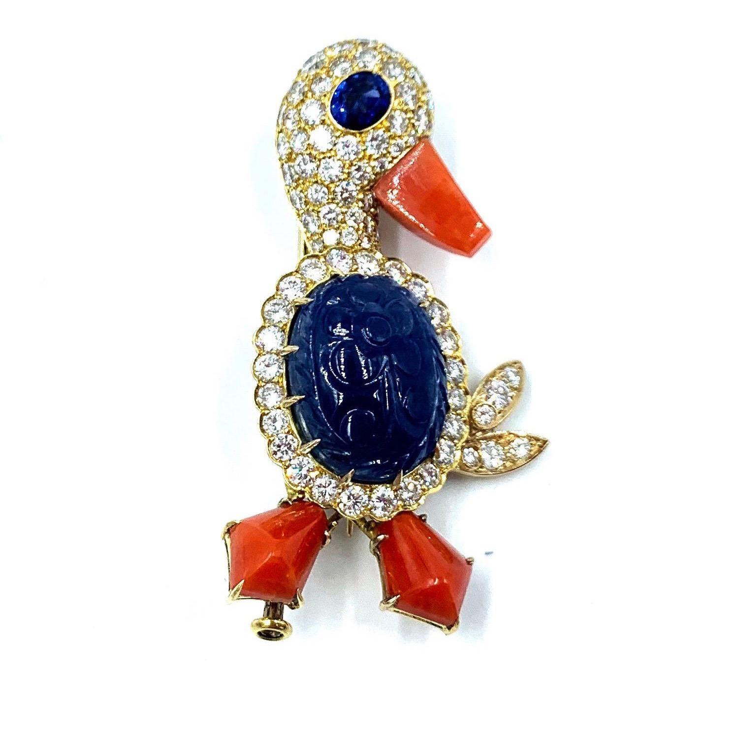 From the prestigious Perderzani jewelry family, a beautifully made duck brooch with an oval-shaped carved sapphire body, as well as a coral beak, and feet. Surrounded by diamonds this duck brooch is set in 18k gold.