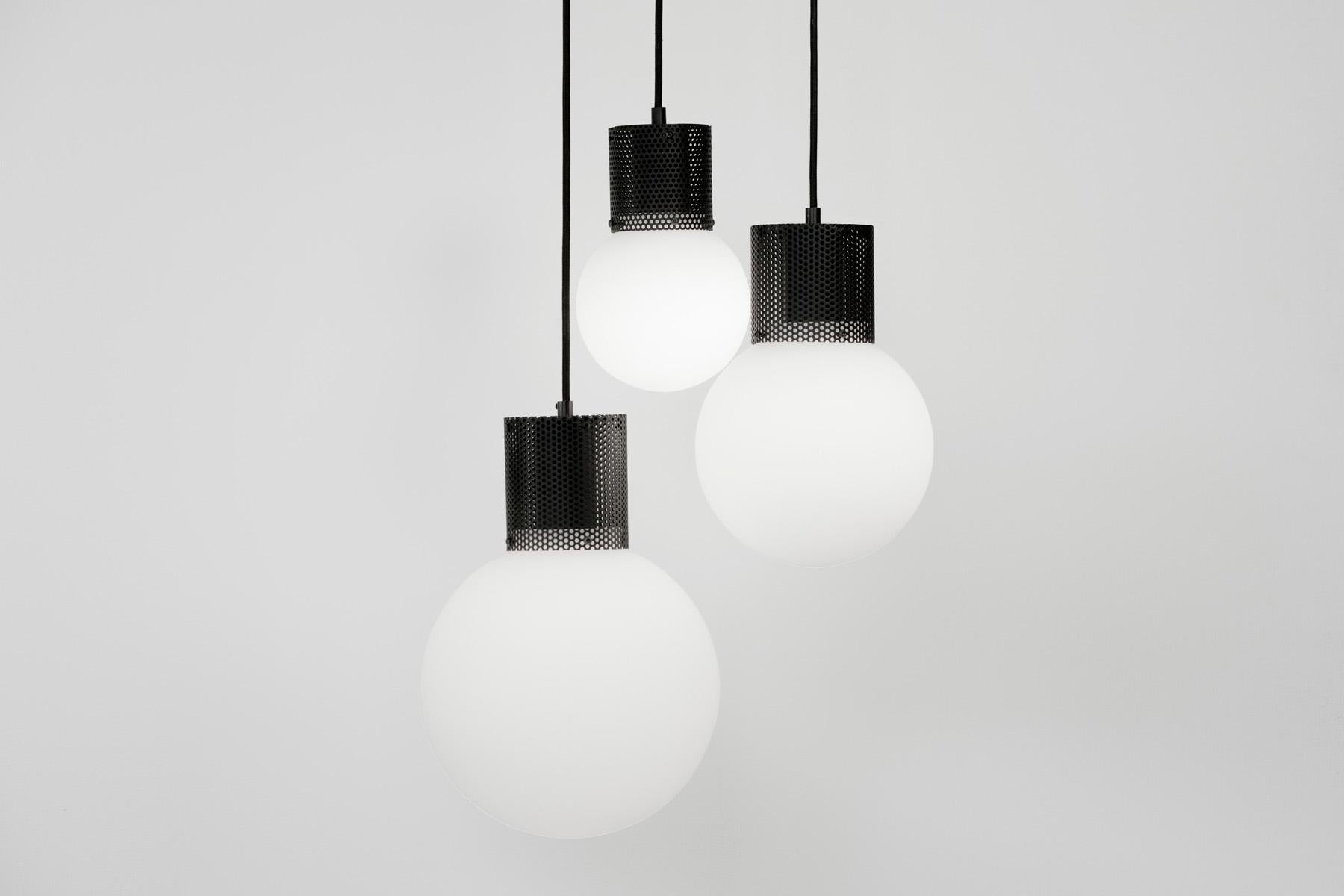 Combining hand blown opal glass with a perforated metal housing, Perf pendant is an elemental and versatile decorative fixture.
Utilizing a low energy LED bulb, Perf pendant is available in 3 sizes and 3 finishes, with custom colors available. 
This