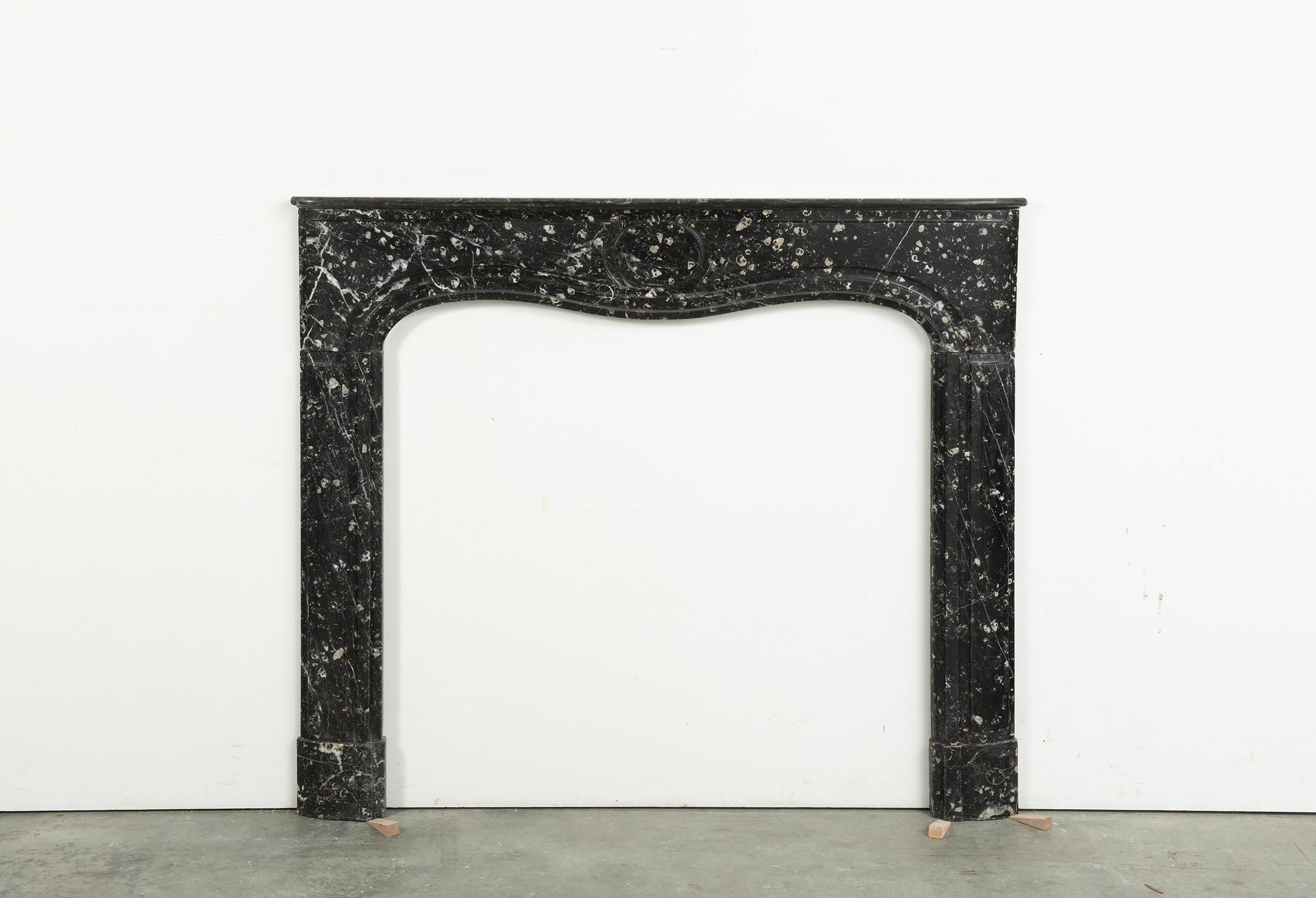 So excited to have this very interesting and serene black and white marble mantel for sale.
This 18th century beauty shows a delicate and shallow profiled and curved shelf that rests on a paneled frieze centered with a simpel yet stylish