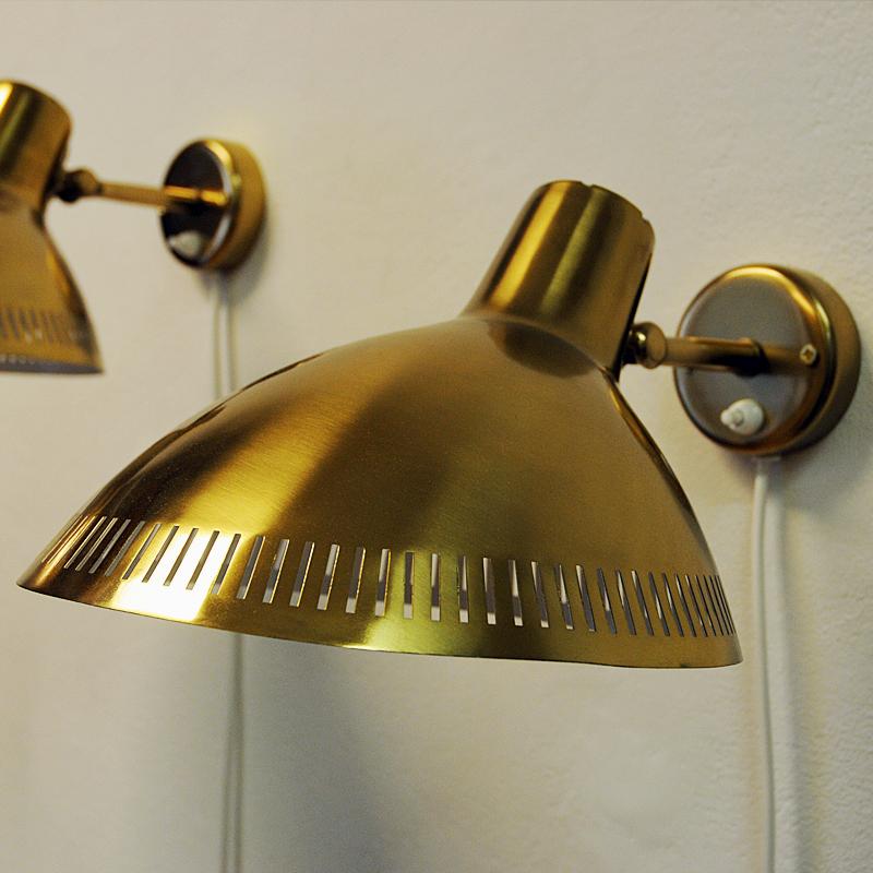 A great pair of brass wall lamps designed by Hans Bergström for Atelje Lyktan, Sweden in the 1960s. Perforated lamp shade edges and white laquered inside. Light switch placed on the base. The oval/circular shades are adjustable upwards and