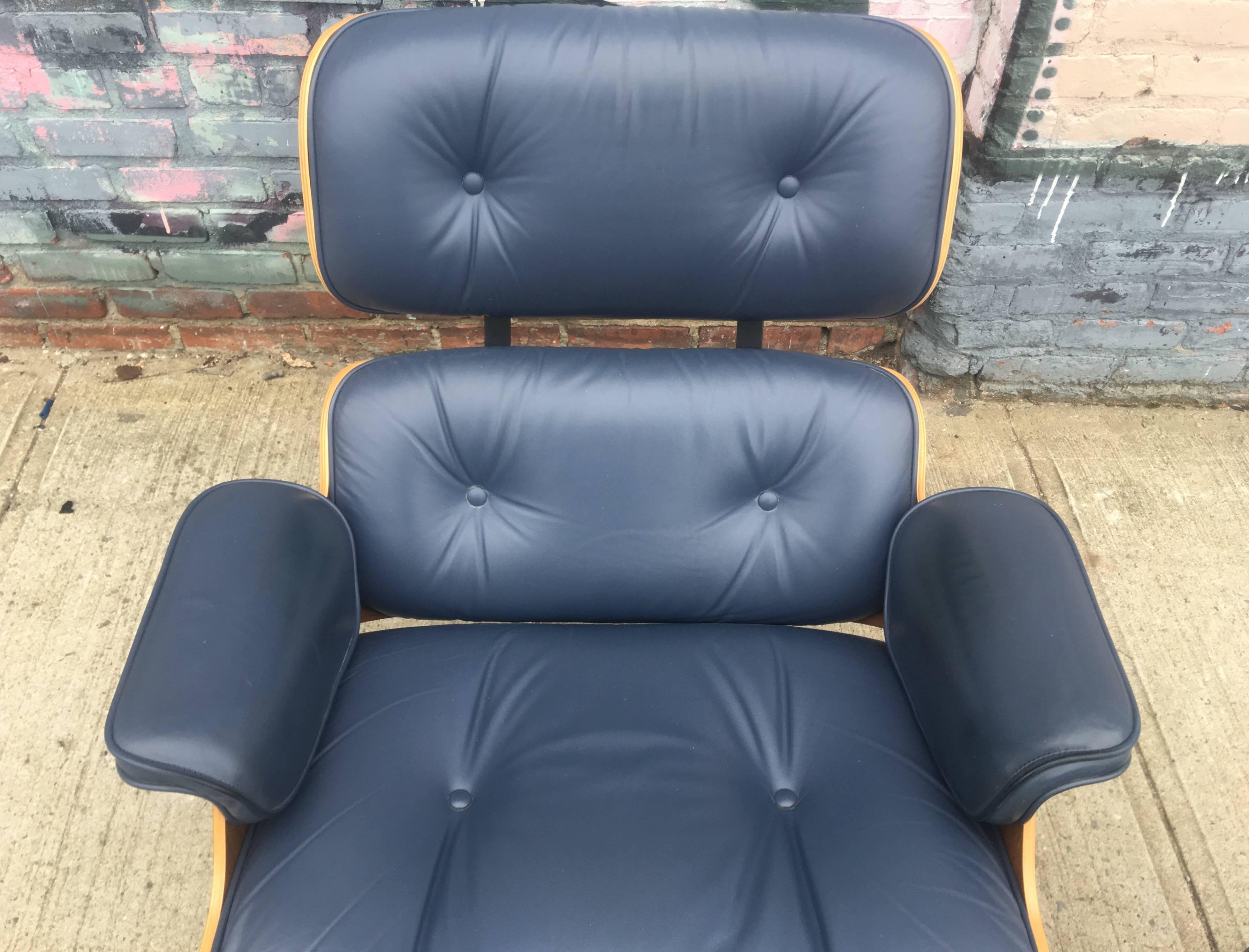 Perfect Herman Miller Eames lounge chair and ottoman in custom blue leather. Walnut shells in perfect condition with warm tones and gorgeous grain detail. We have only come across this color on one other occasion. Signed on chair and ottoman.