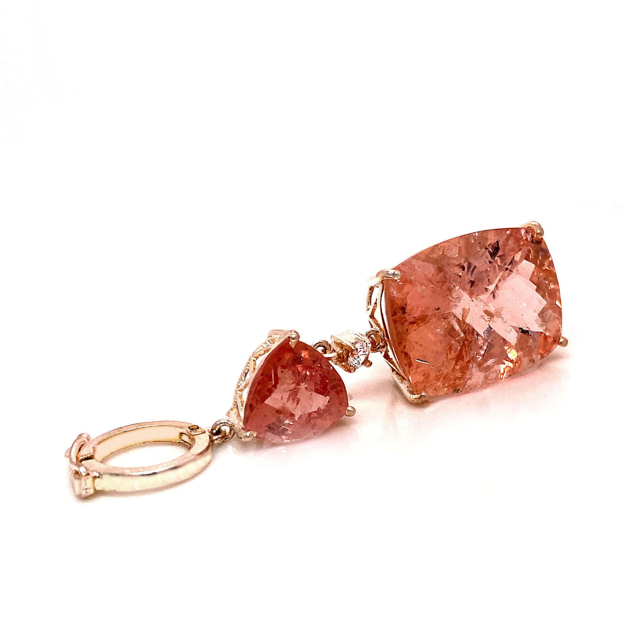 Delightful tangerine color Morganites create this unique pendant.  Wear these gemstones for a touch of sparkle and magic.  This Gemjunky pendant features two Morganites, one is a rectangular cushion cut 19.70 carats.  The triangular Moragnite is