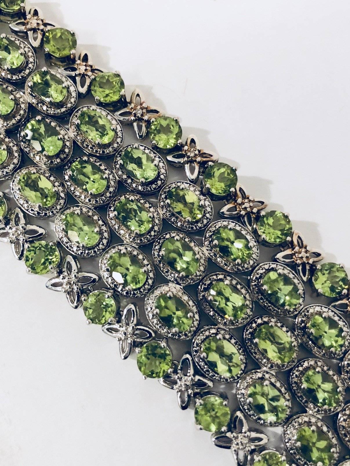 Fabricated in sterling silver, this is a one of a kind peridot and diamond bracelet!  It began with three rows of oval, faceted, beautifully matched peridots in diamond wreaths.  Two additional bracelets were purchased and soldered on to the
