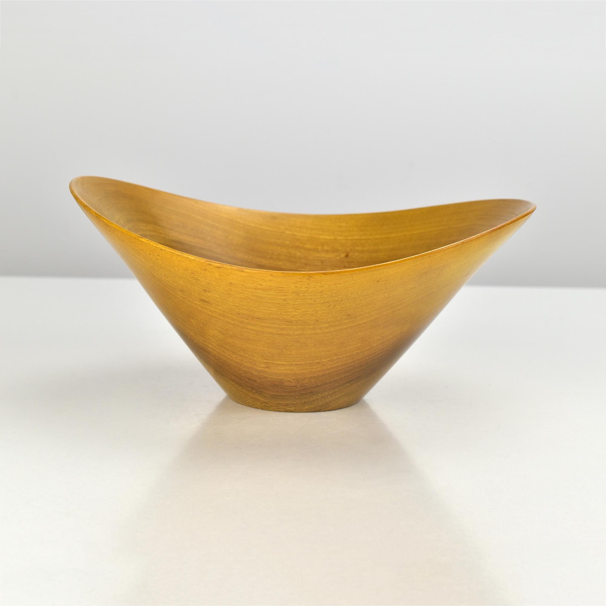 Splendida ciotola in legno di teak della metà del secolo scorso, realizzata a mano, con un'elegante silhouette organica e biomorfa che ricorda l'estetica minimalista di Carl Auböck. La forma scultorea, caratterizzata da curve morbide e da una patina