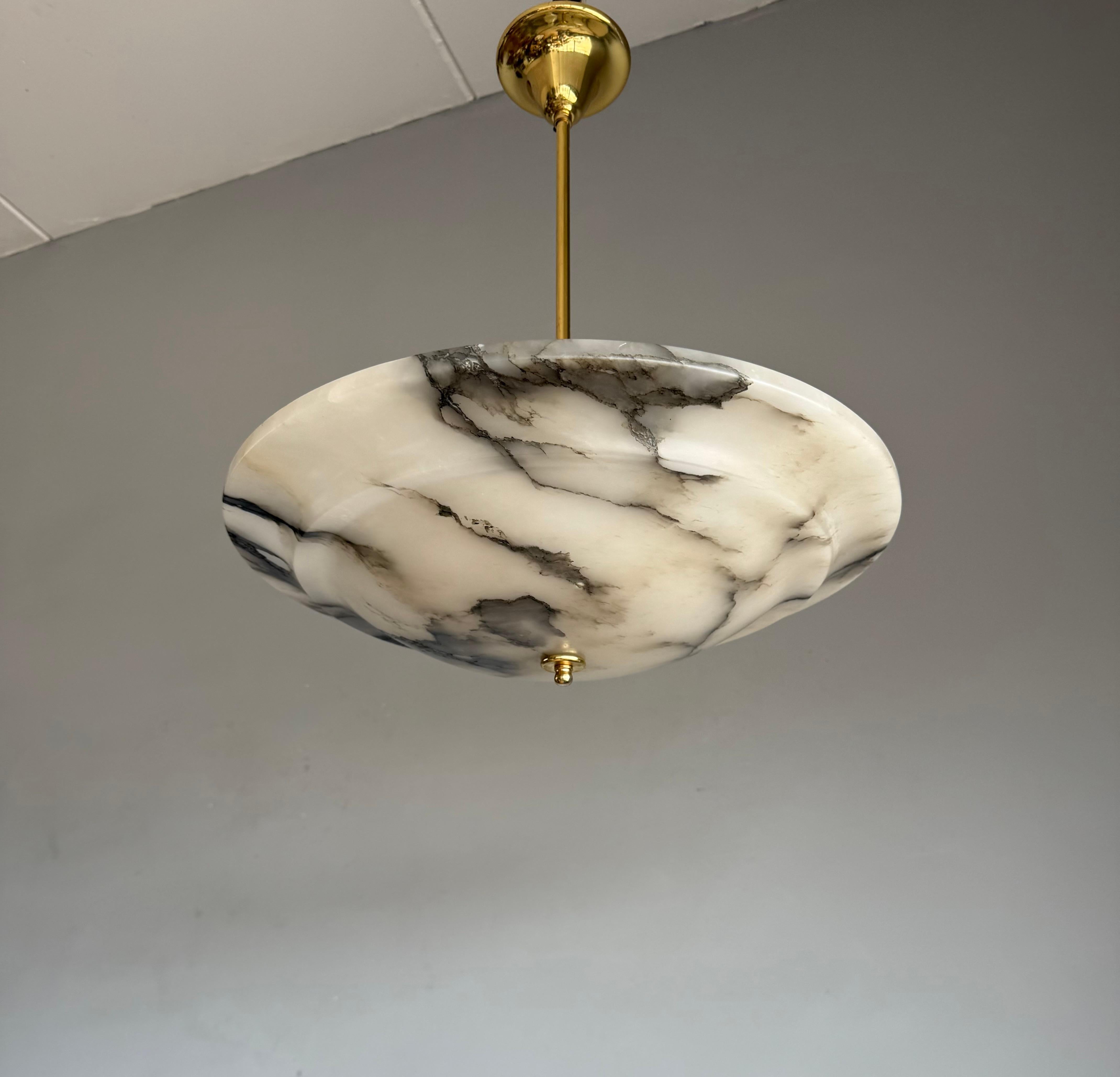 Lampada a sospensione in alabastro Art Deco con venature audaci, ricablata per l'uso negli Stati Uniti.

Questa splendida lampada da soffitto in stile Art Déco unisce senza sforzo eleganza e drammaticità. Caratterizzato da un raro paralume piatto in