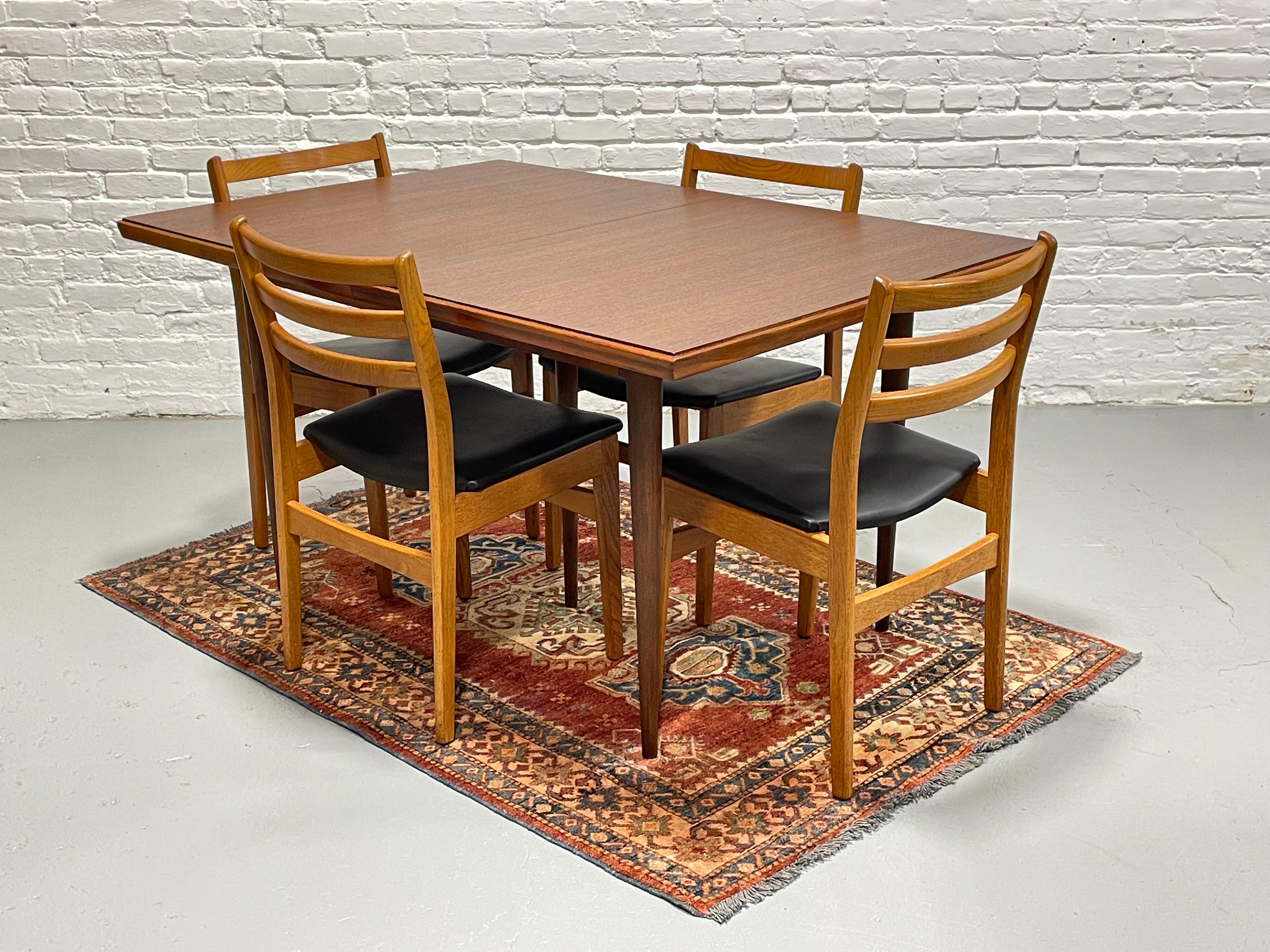 Perfectly sized Mid Century Modern WALNUT DINING TABLE, c. 1960's. Comfortably seats 4-8 guests yet won't overwhelm a room. Solidly built from walnut wood with long tapered legs and a freshly refinished tabletop.  The table includes an expansion