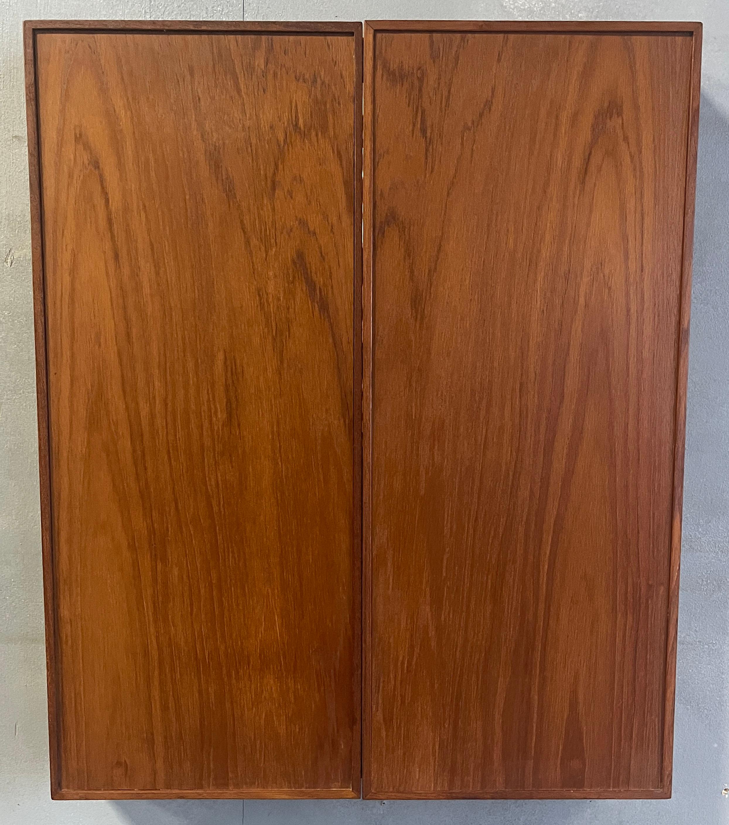 Folding tri-fold / triptych tabletop or wall-mounted mirror crafted in teak designed by Kai Kristiansen for Aksel Kjersgaard (circa 1960s, Denmark) composed of three hinged-sections (the two end sections can fold in partially or fully). Equipped