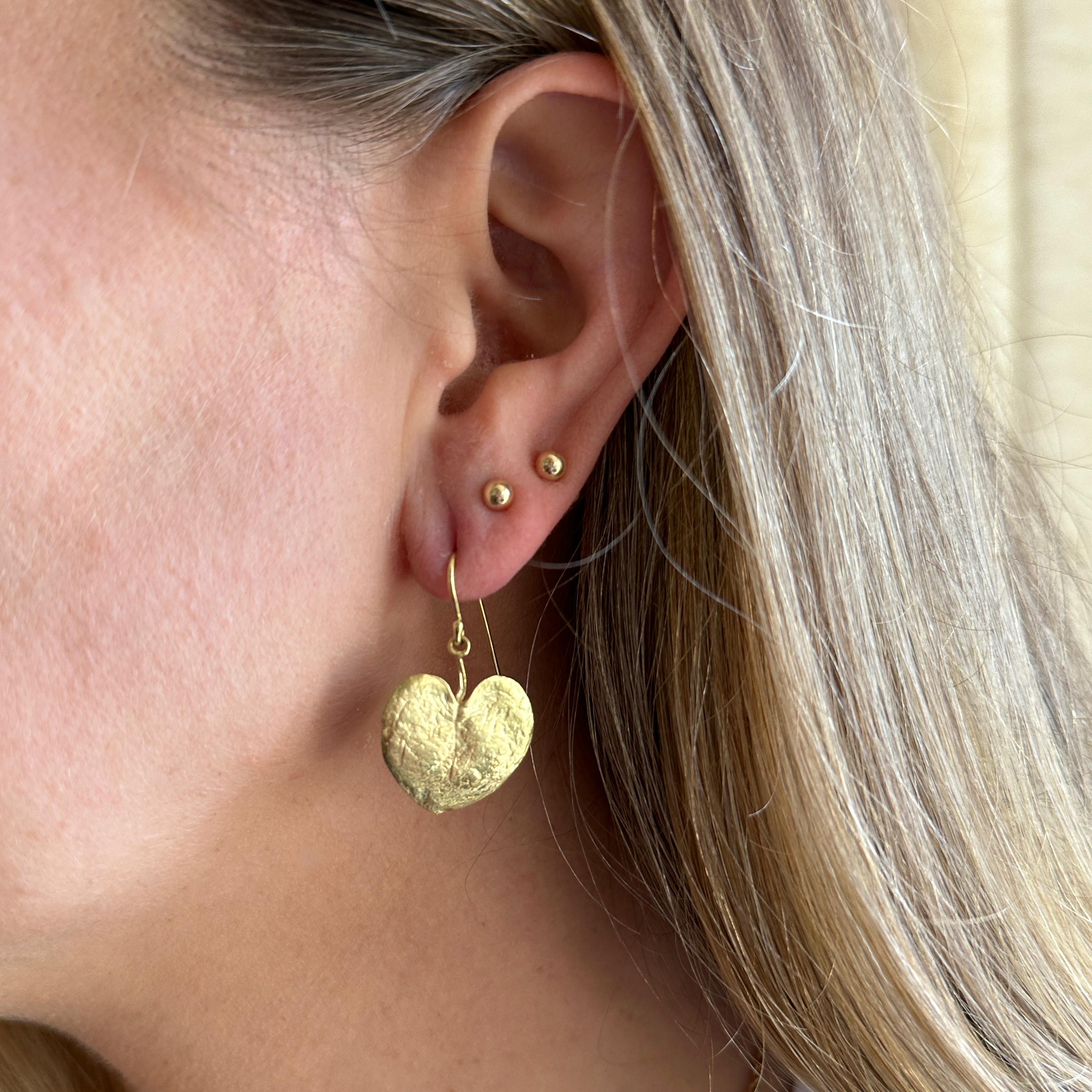 Eytan Brandes used actual leaves to make the wax molds for these earrings, so they're naturally mismatched, whisper-thin and super-lightweight.  

The stems are hinged to shepherd's hook closures.  Simple but not demure and very fun to wear in rich,