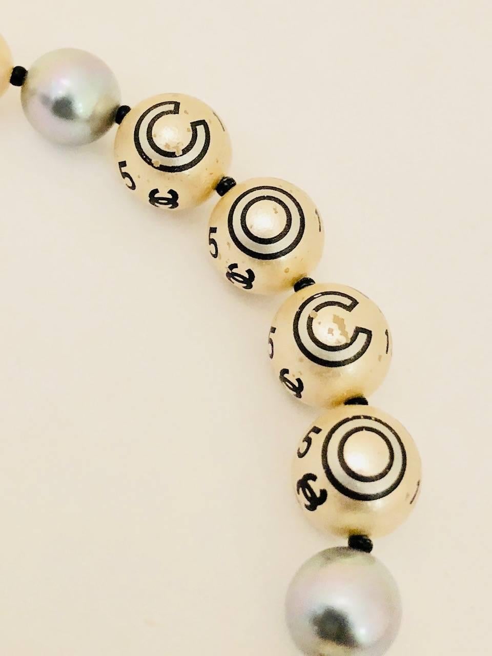 Attention lovers of all items Chanel!  A most unique faux pearl necklace from 2005.  Pearls range in size from 6mm to 11mm along with three grey pearls 8mm each.  This rare piece is distinguished by the fact that pearls are printed!  One side spells