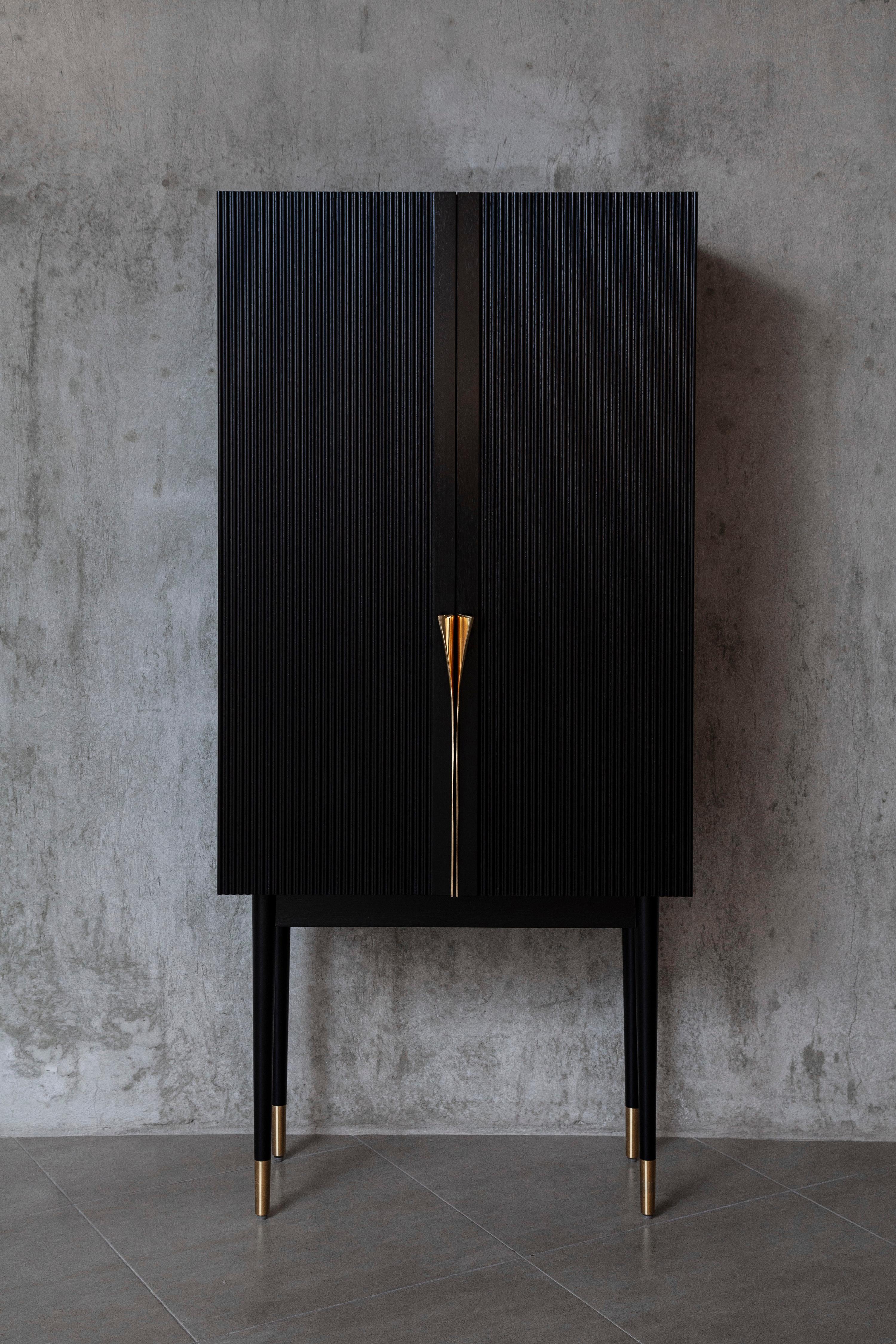 Mueble Bar Perfidia en Madera Maciza con Detalles en Bronce Fundido by Estudio Andean
Dimensiones: P 43,8 x An 85 x Al 185 cm. 
Materiales: Madera maciza, bronce fundido, acero y espejo envejecido.

Mueble bar fabricado con cuerpo de madera maciza