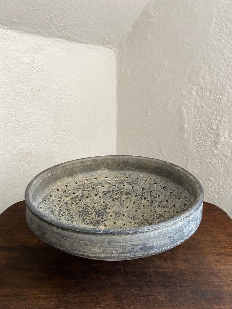 Perforated ceramic nixtamal bowl from San Bartolo Coyotepec, Oaxaca. Used to rinse maize after it has been cooked in lime water. Rare and beautifully crafted piece. Its original color was black, however it has turned gray from time and use.