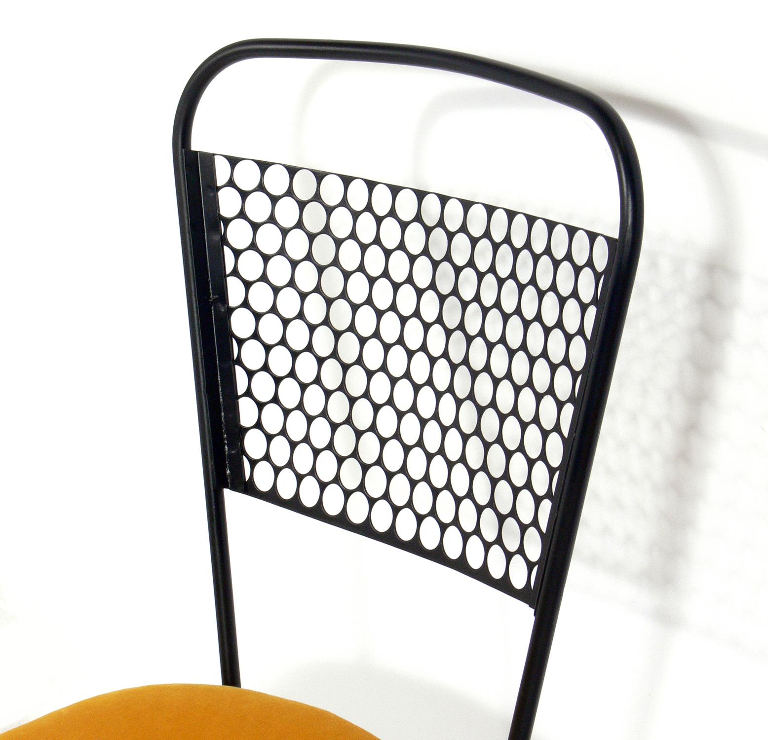 Perforated iron midcentury dining chairs, attributed to Mathieu Matégot, France, circa 1950s. They have been repainted and reupholstered in a goldenrod yellow velvet.