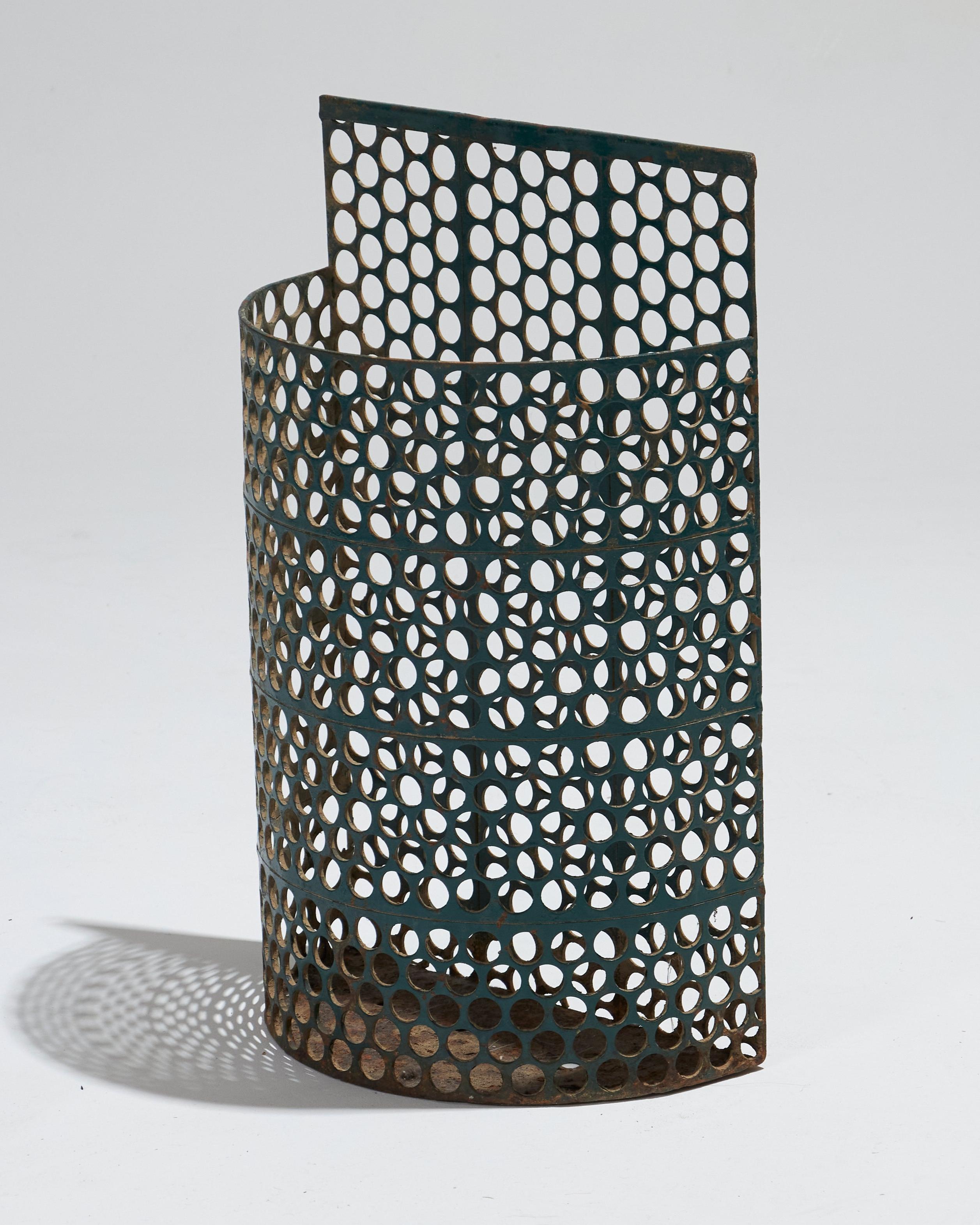Outdoor basket in green-patinated perforated metal, by Jean Bossu, 1940s. Featuring a semi-circular shape and honeycomb pattern, it can also be used as an umbrella stand. Some minor losses to the metal consistent with the age of the