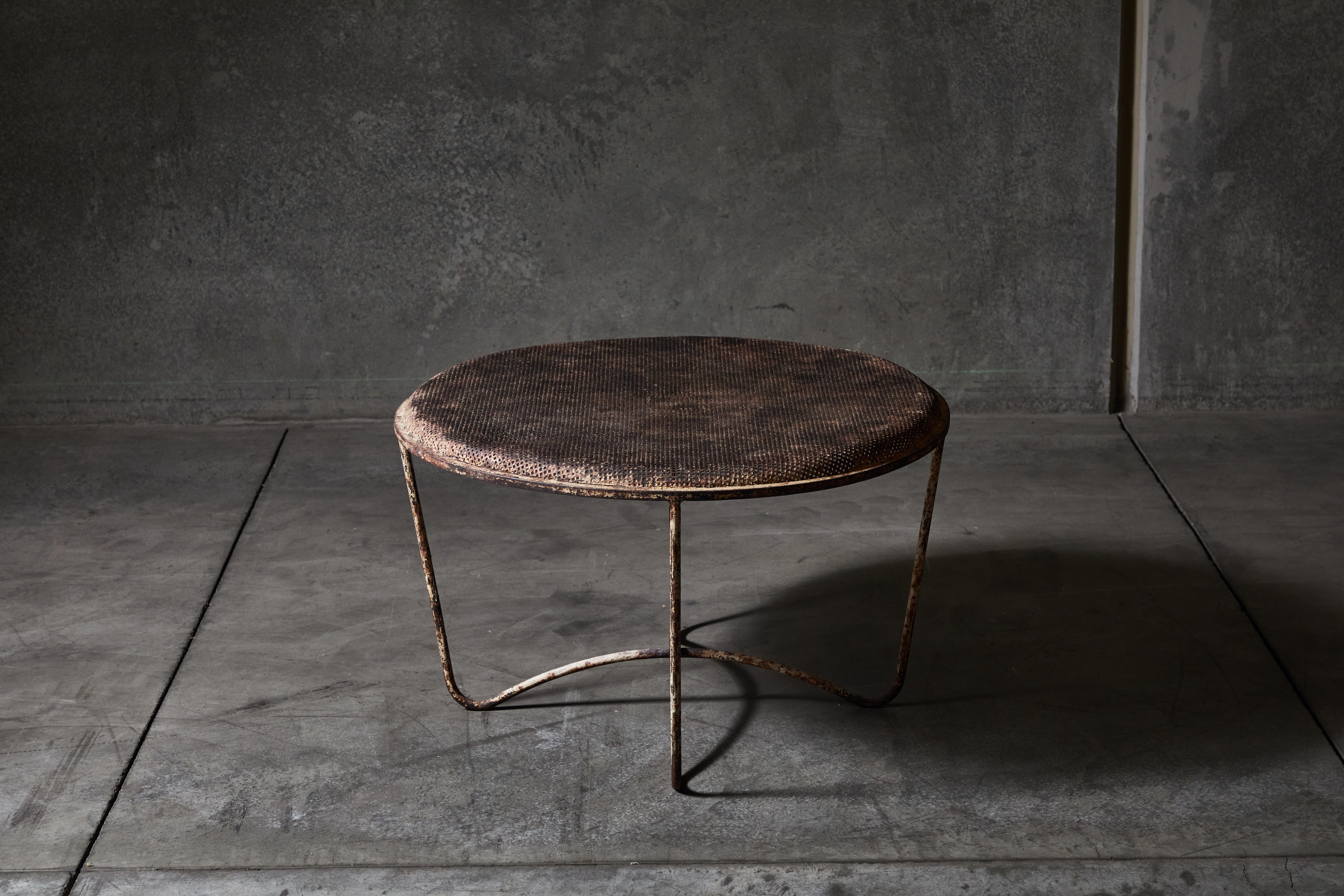 Patinated circular coffee table by Mathieu Matégot. Made in France, circa 1950s.