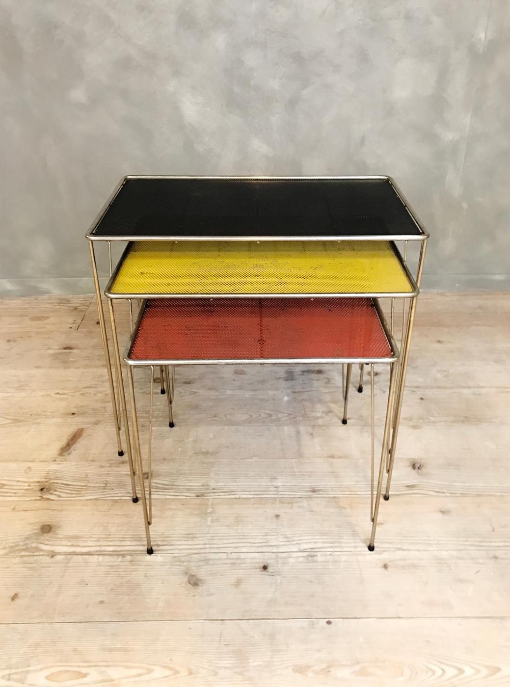 This set of three nesting tables features perforated metal tops in black, yellow, and red, set on hairpin legs. They were probably made in France reminding of Mathieu Matego.