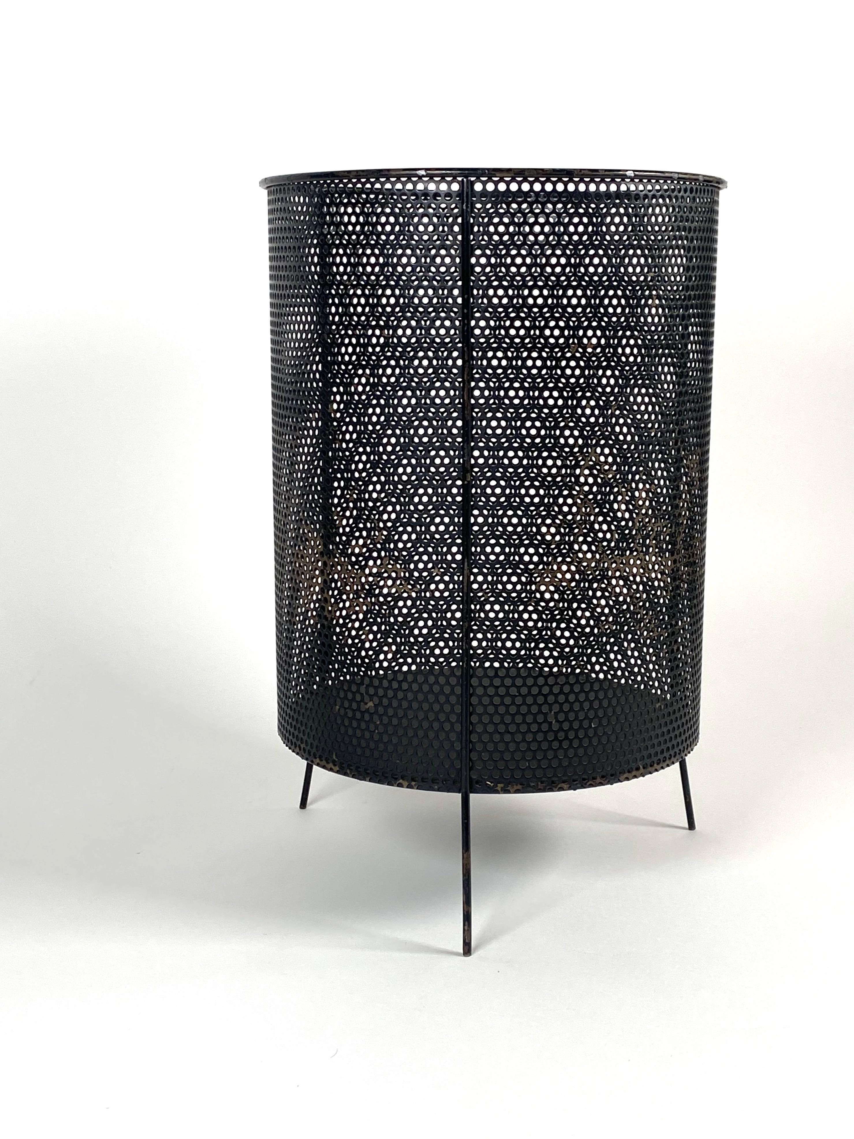 All original black perforated metal cylinder wastepaper basket with a tripod base, designed by industrial designer Richard Galef during the 1950s and sold by Raymor. Normal wear to the black paint finish from use, we can re-lacquer the piece upon