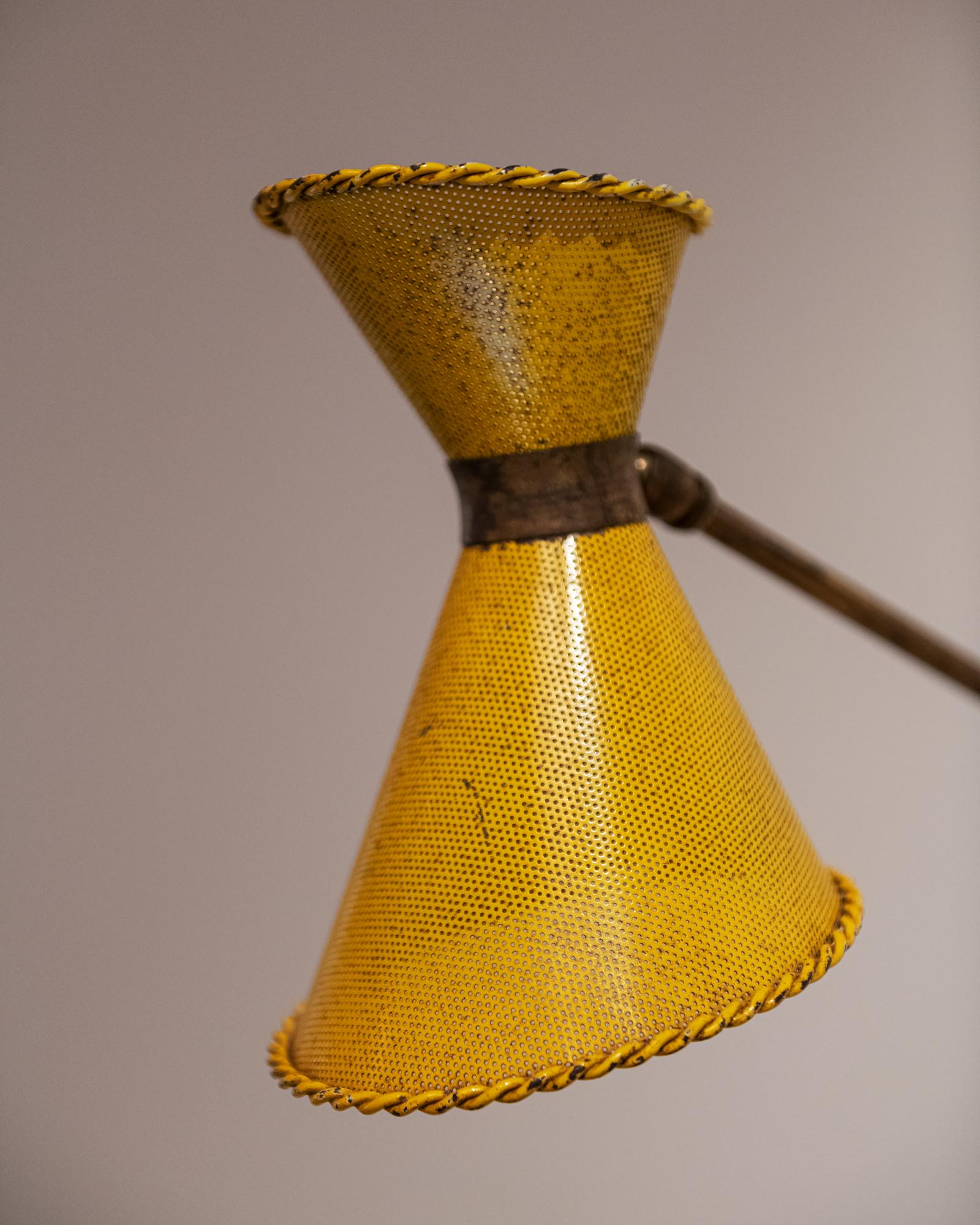 Wall sconce with perforated shade in yellow, with brass fixtures, attributed to Mathieu Matégot. France, 1950s. Rewired for the US. 

Measures: Shade height: 8.25 in
Shade diameter 6 in.