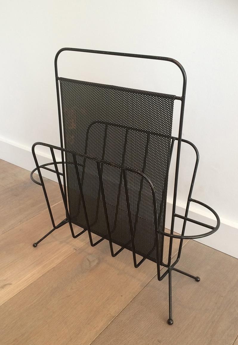 This is a very nice magazine rack made of black lacquered perforated sheet of metal. This is a work by famous designer Mathieu Matégot Circa 1970.
