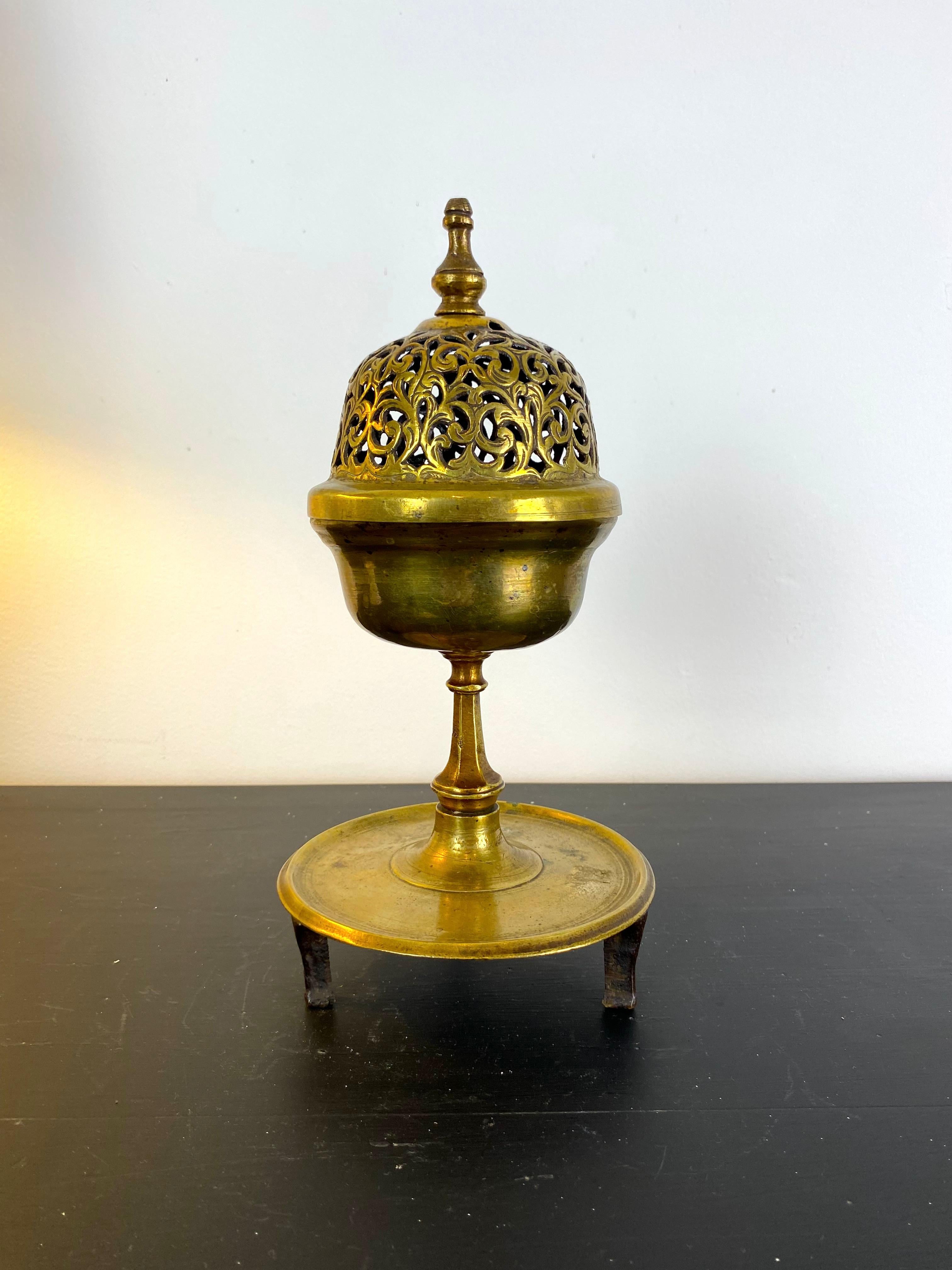Ottoman brass incense burner with incised and openwork decoration.
The domed lid is topped with a grip, it is decorated with openwork scrolls.
The incense burner rests on a circular base with three feet
The whole is in gilded brass.

Turkey, Ottoman