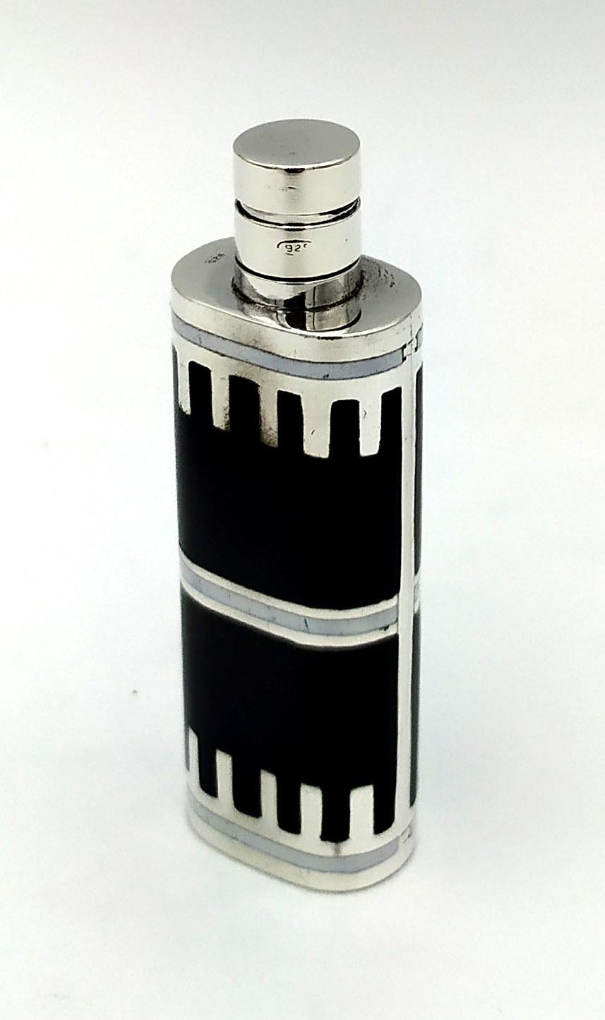  Portaprofumo da borsetta ovale in argento 925/1000 con tappo a vite e incisione geometrica smaltata a fuoco, in stile Art Déco, inizio '900. Misure cm. 1,5 x 2 altezza totale cm. 6,3, peso gr. 40. Disegnata da Franco Salimbeni nel 1970 e prodotta