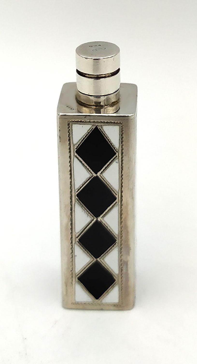 This exclusive handbag perfume holder is in 925/1000 sterling silver.
it has a fine geometric manual engraving with rhombuses and white and black in Art Deco for the fire enameled surface.
Black and white handbag perfume holder has a natural silver