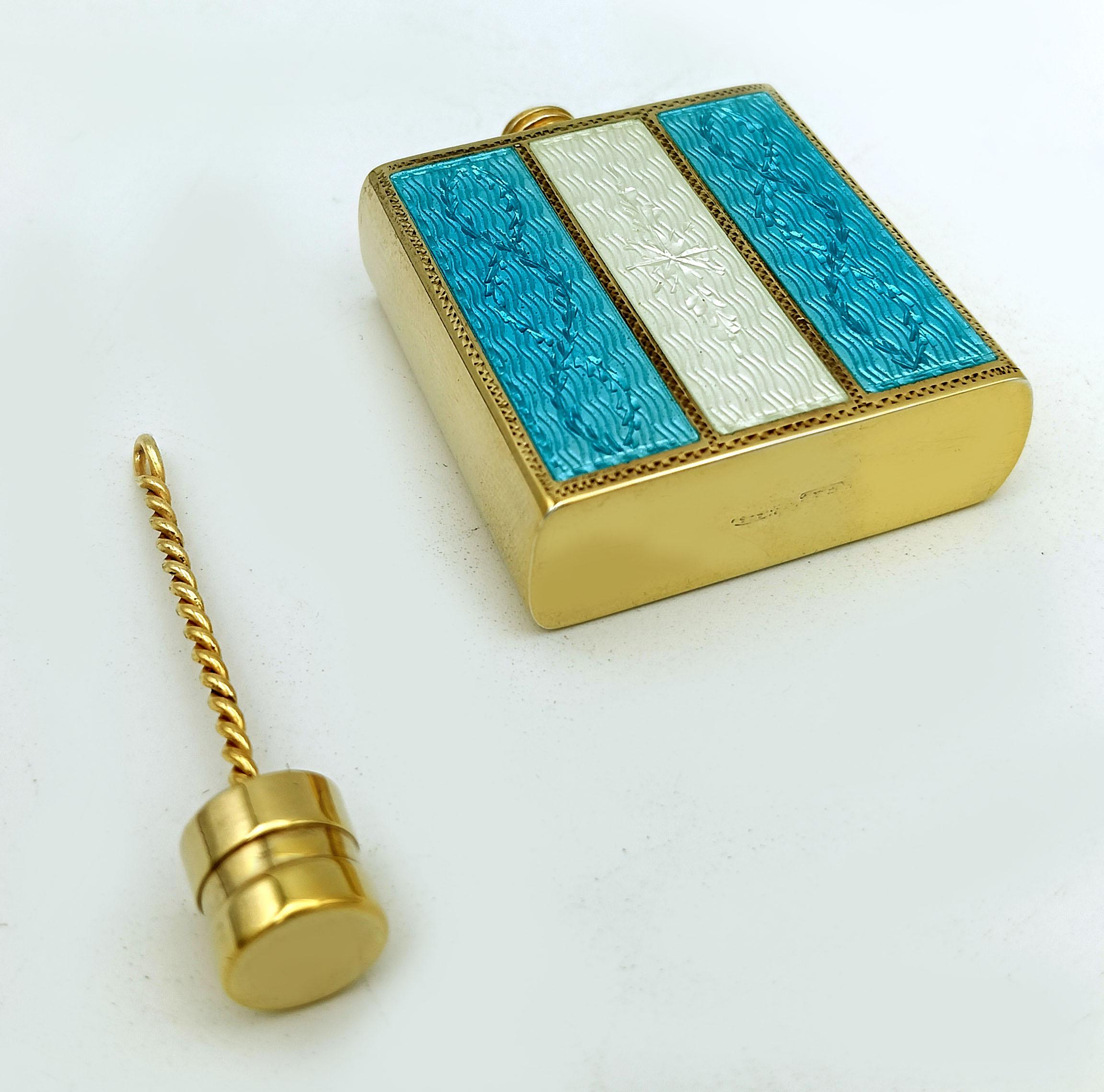 Portaprofumo da borsetta rettangolare in argento 925/1000 placcato oro con tappo a vite e strisce con smalti cotti traslucidi bicolore su guilloché e motivi incisi a mano in stile Impero. Dimensioni 4 x 4 x 1,3 cm, altezza totale 5 cm, peso 56 g.