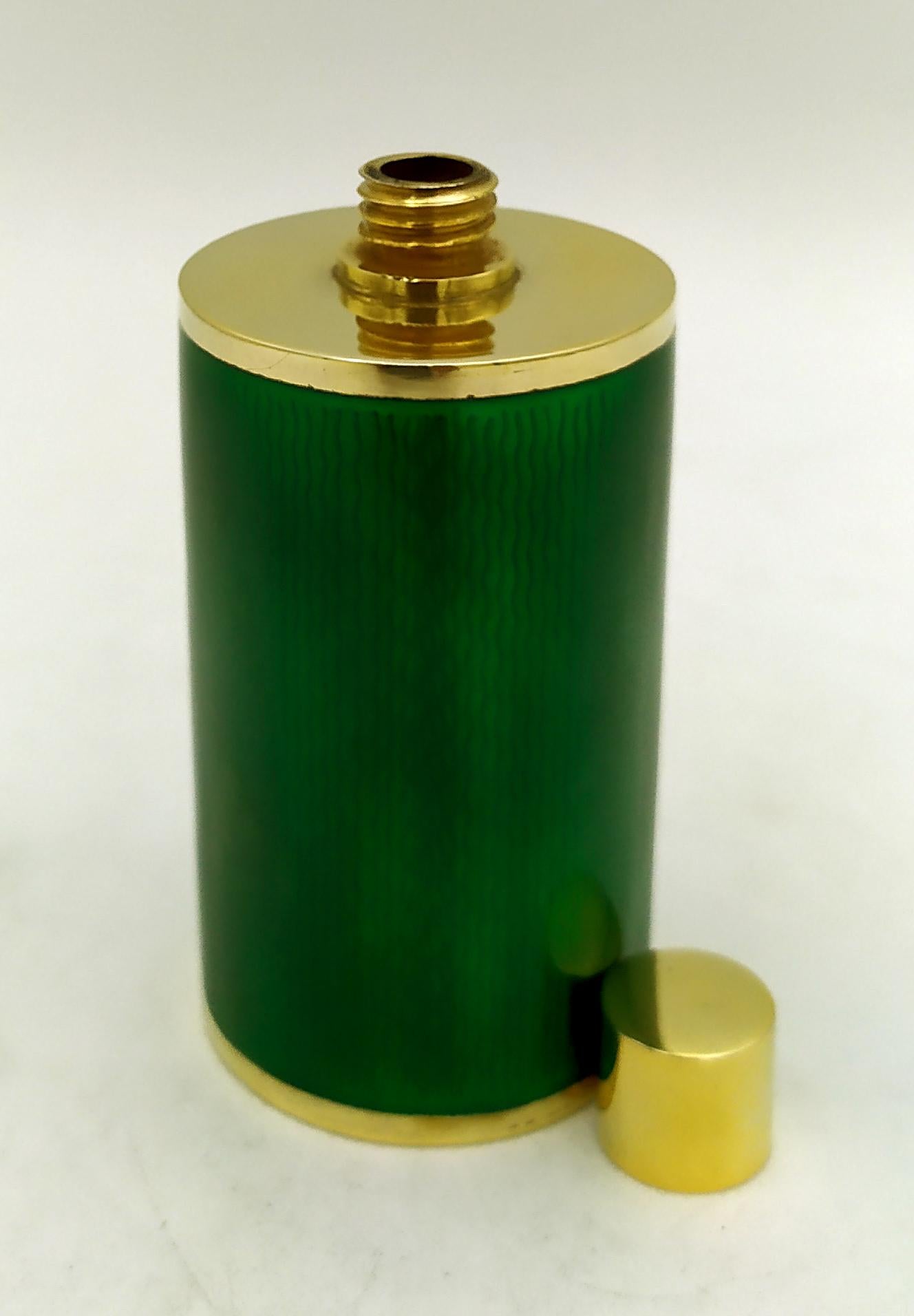 Cylindrical perfume holder in gold-plated 925/1000 sterling silver with translucent enamel fired on guilloche, with screw cap, in a modern contemporary style. Diameter cm, 4,2 cm high bottle. 7, total height cm. 8.5. Silver weight gr. 145. Designed