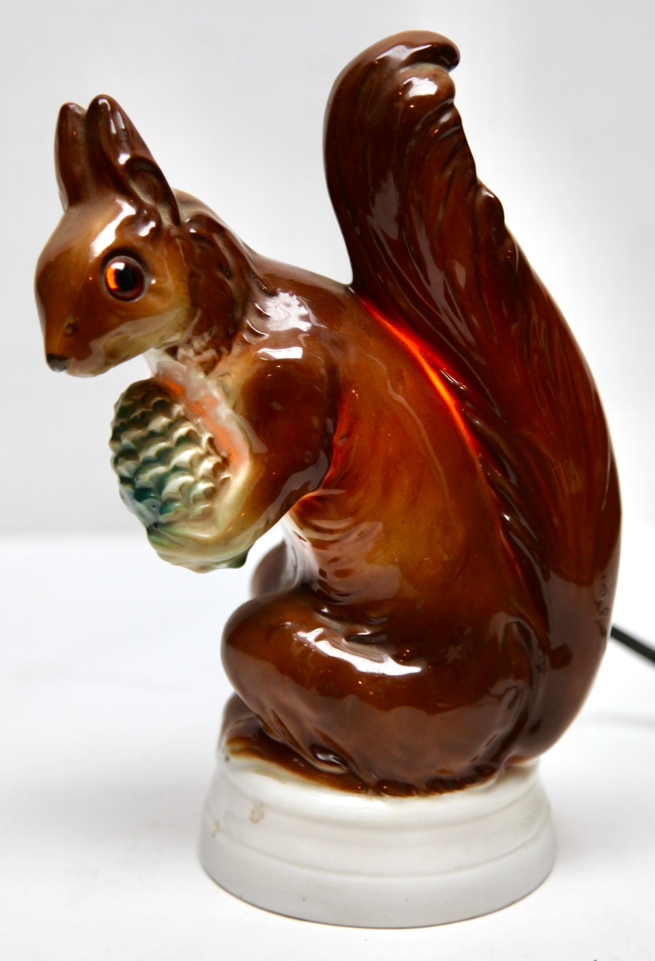 Lampe à parfum en forme d'écureuil attribuée à Carl Scheidig Grafenthal, Allemagne. 
Fabriqué en porcelaine émaillée. 
Pièces électriques Normes européennes avec une ampoule intérieure (norme E 14) pour une lumière nocturne chaleureuse et