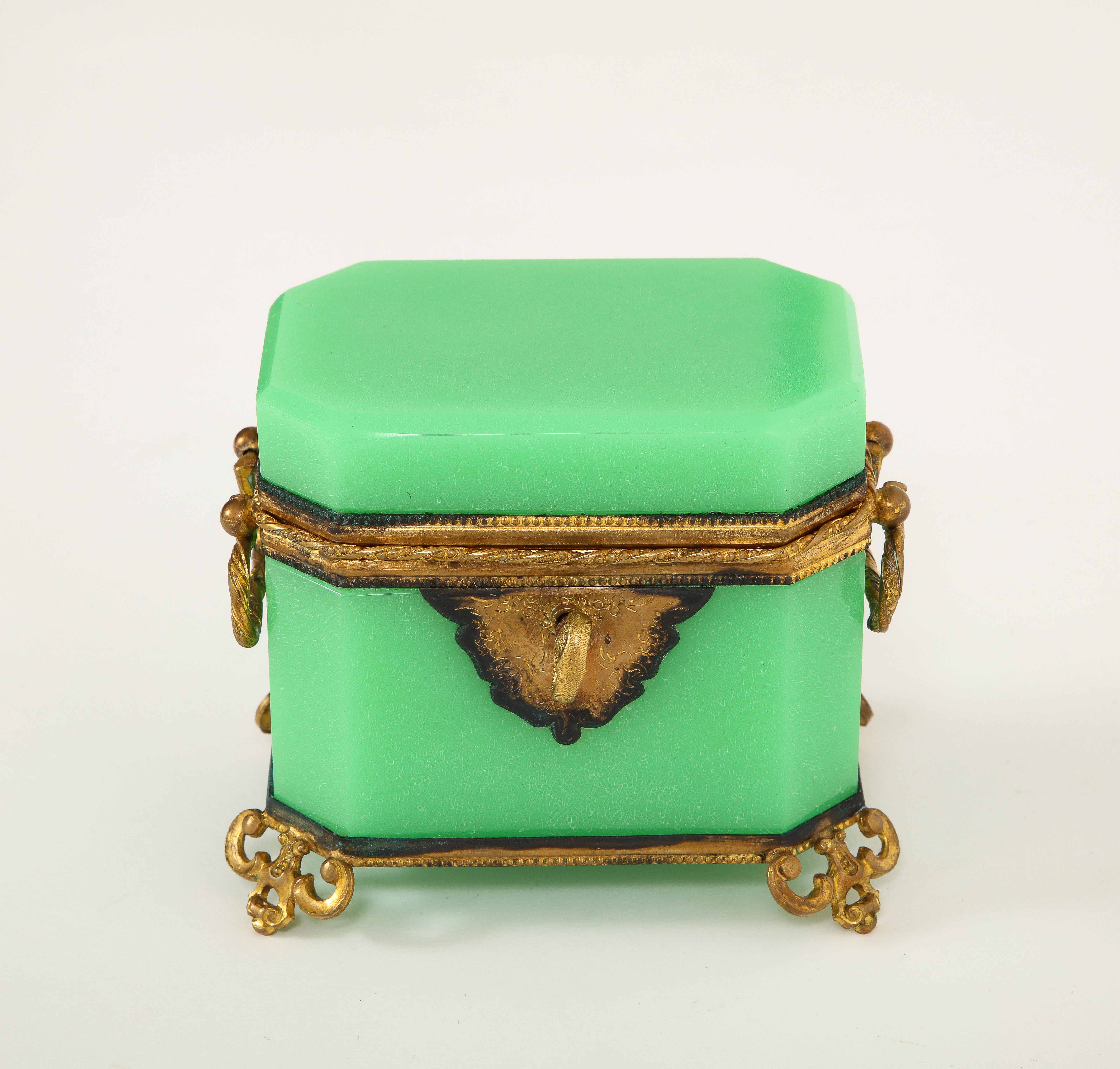 Perfumero Baccarat, Montado en Ormolu, Bronce Doré 

Presentando una notable fusión de arte y opulencia, el perfumero de cristal opalino verde de Baccarat desprende una belleza exquisita. Realzada con adornos de bronce dorado, esta caja es una
