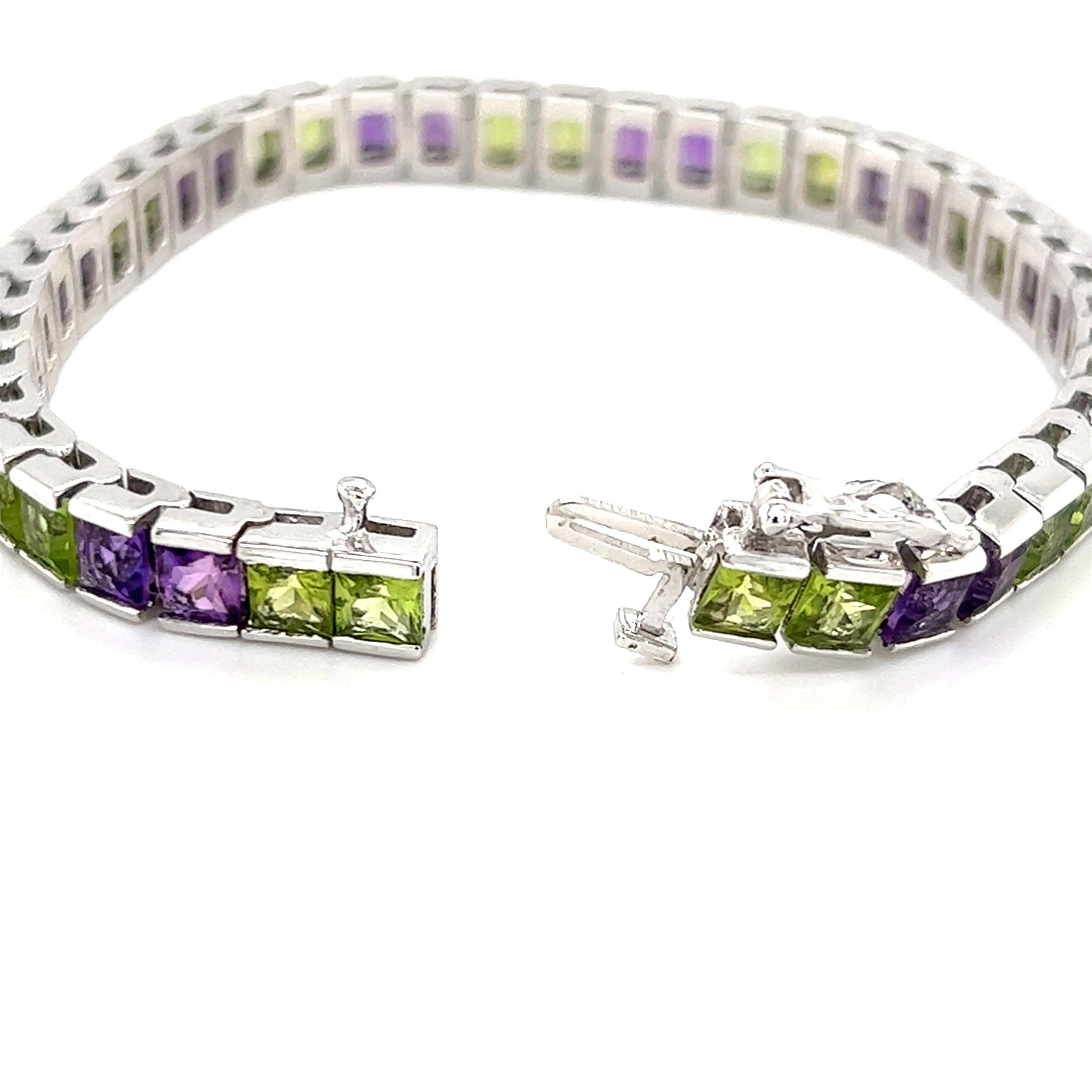 One 14-karat white gold channel set bracelet featuring twenty-two (22) princess cut peridots, approximately 8.18-carat total weight and twenty (20) princess cut amethysts, approximately 6.40-carat total weight.  The bracelet measures 7 inches long