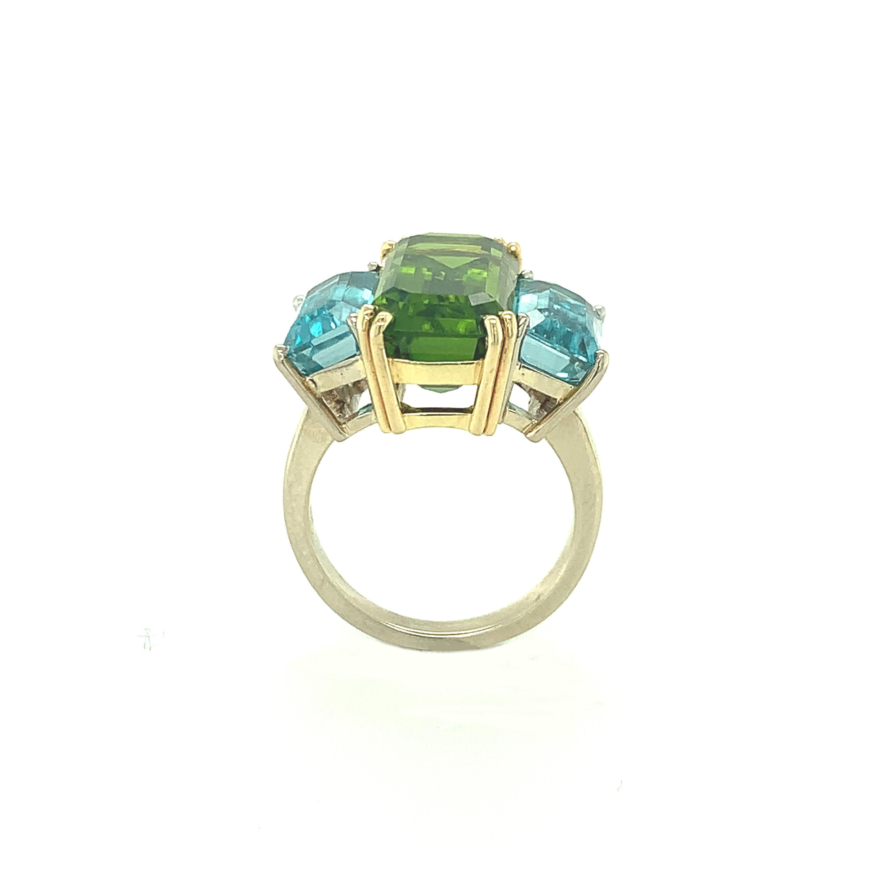 This gorgeous color pairing of stunning green and blue combines a fine, crystal clear peridot with brilliant blue zircon! The center peridot is large, weighing 10.41 carats, and is exceptionally bright. The blue zircon side stones are faceted as