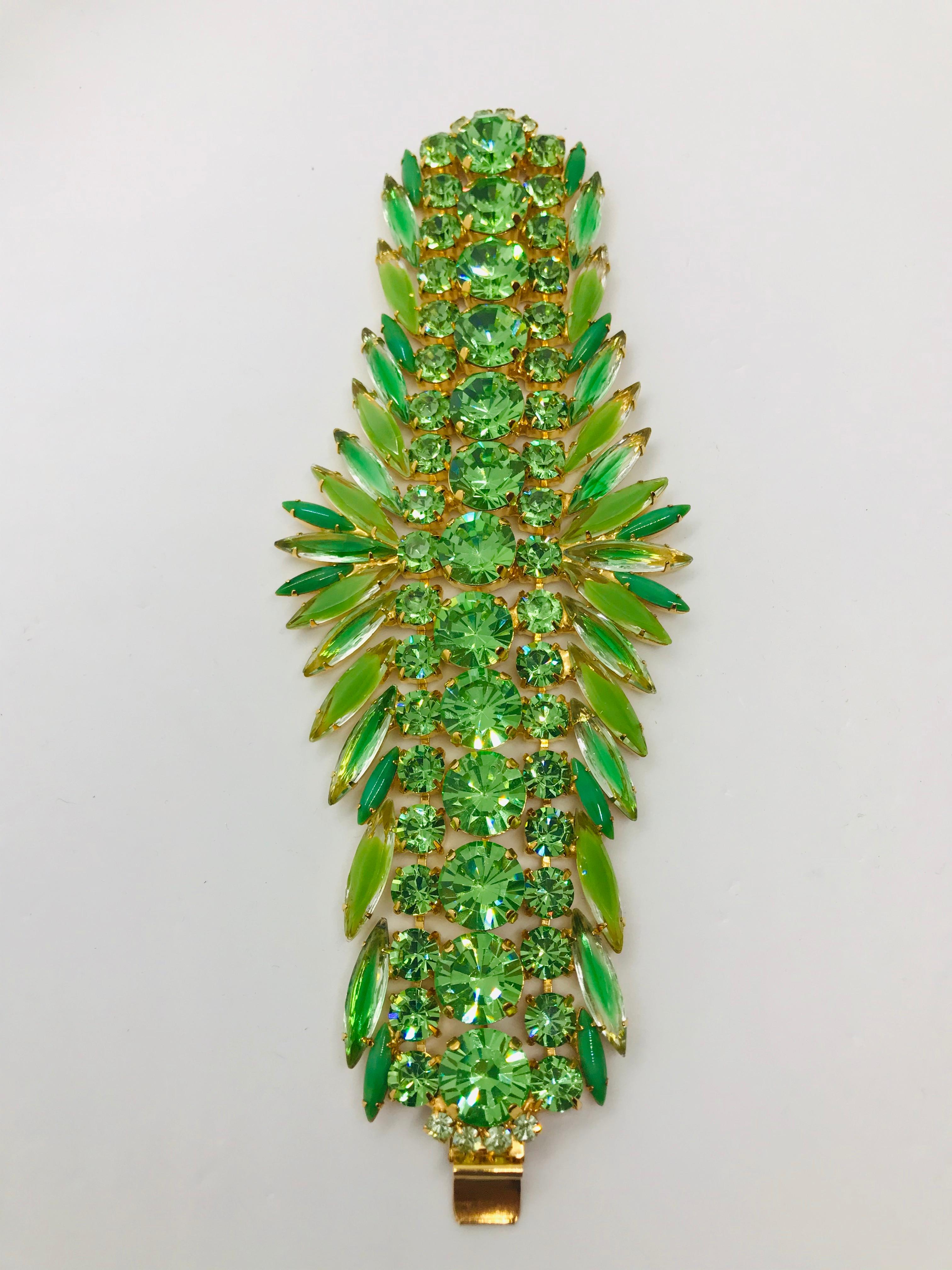 This flexible cuff bracelet in peridot and chrysolite vintage Austrian crystals is fluid on the wrist and can be worn any season of the year.  This bracelet features a center row of large round peridot vintage Swarovski stones from the 1960s  The