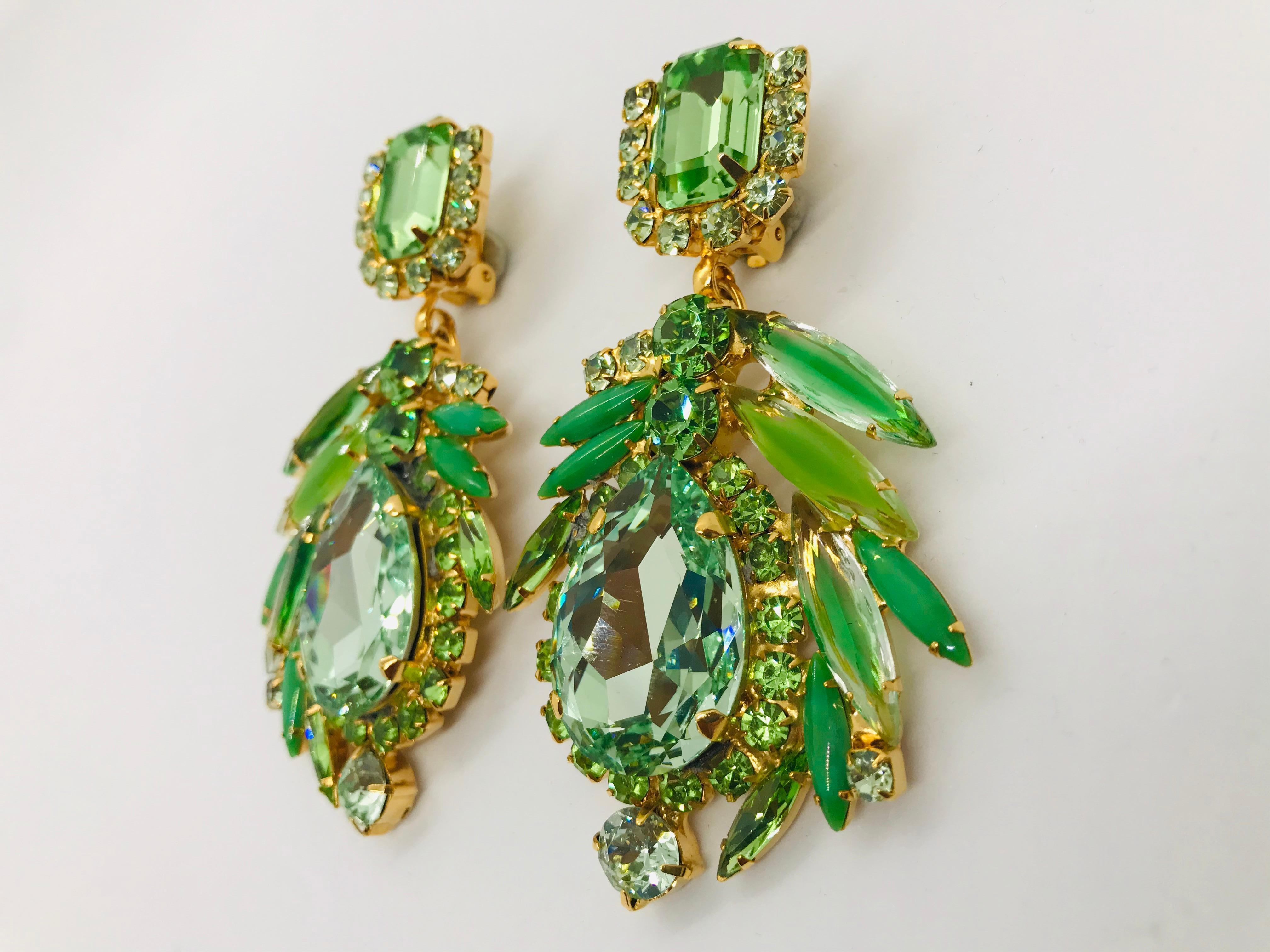 Dramatic peridot and chrysolite Austrian crystal pendant drop earrings add a bold statement to any outfit!  These multi shade green earrings feature jade, peridot and shaded chrysolite navettes from the 1960s swirling around contemporary Swarovski