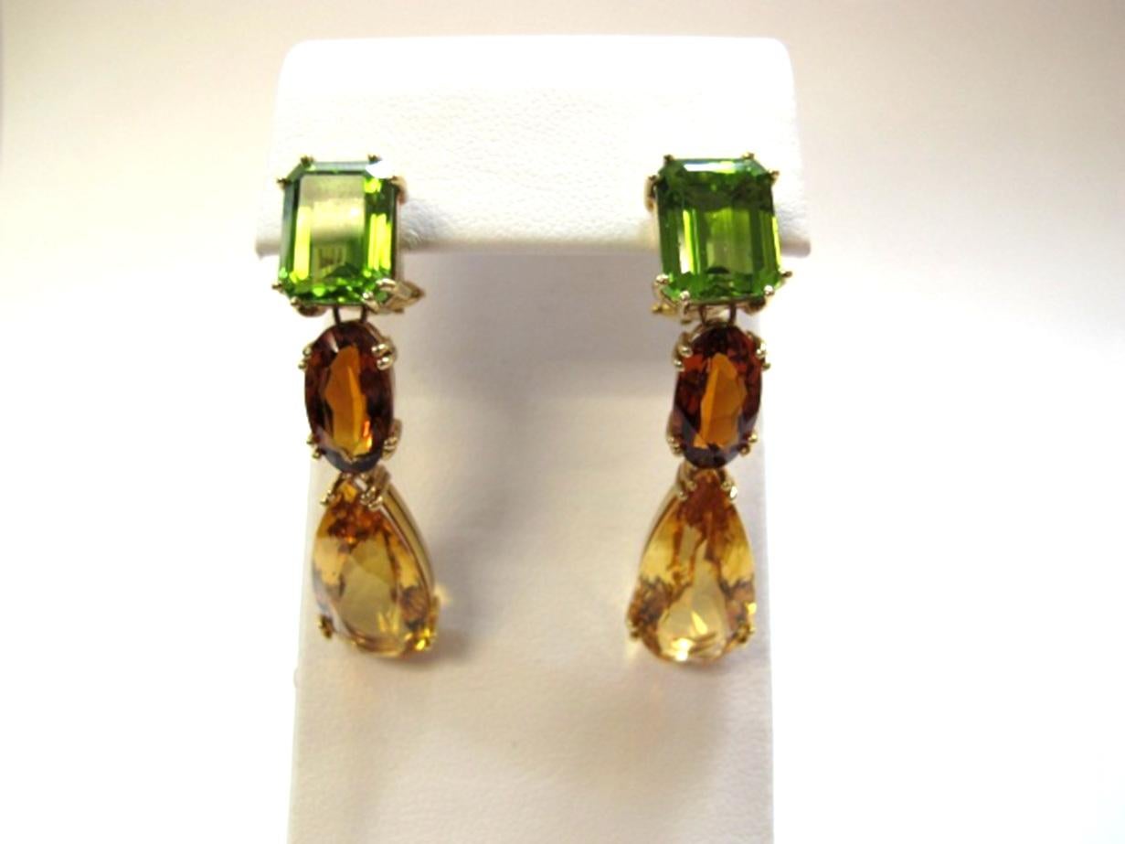 Fall colors rendered in gemstones! Handmade earrings include emerald cut peridots (8.40cts/10 x 8 mm) with oval and pear shaped citrines (14.70cts). These 18k yellow gold earrings are one-of-a-kind and a beautiful marriage of color & shape.