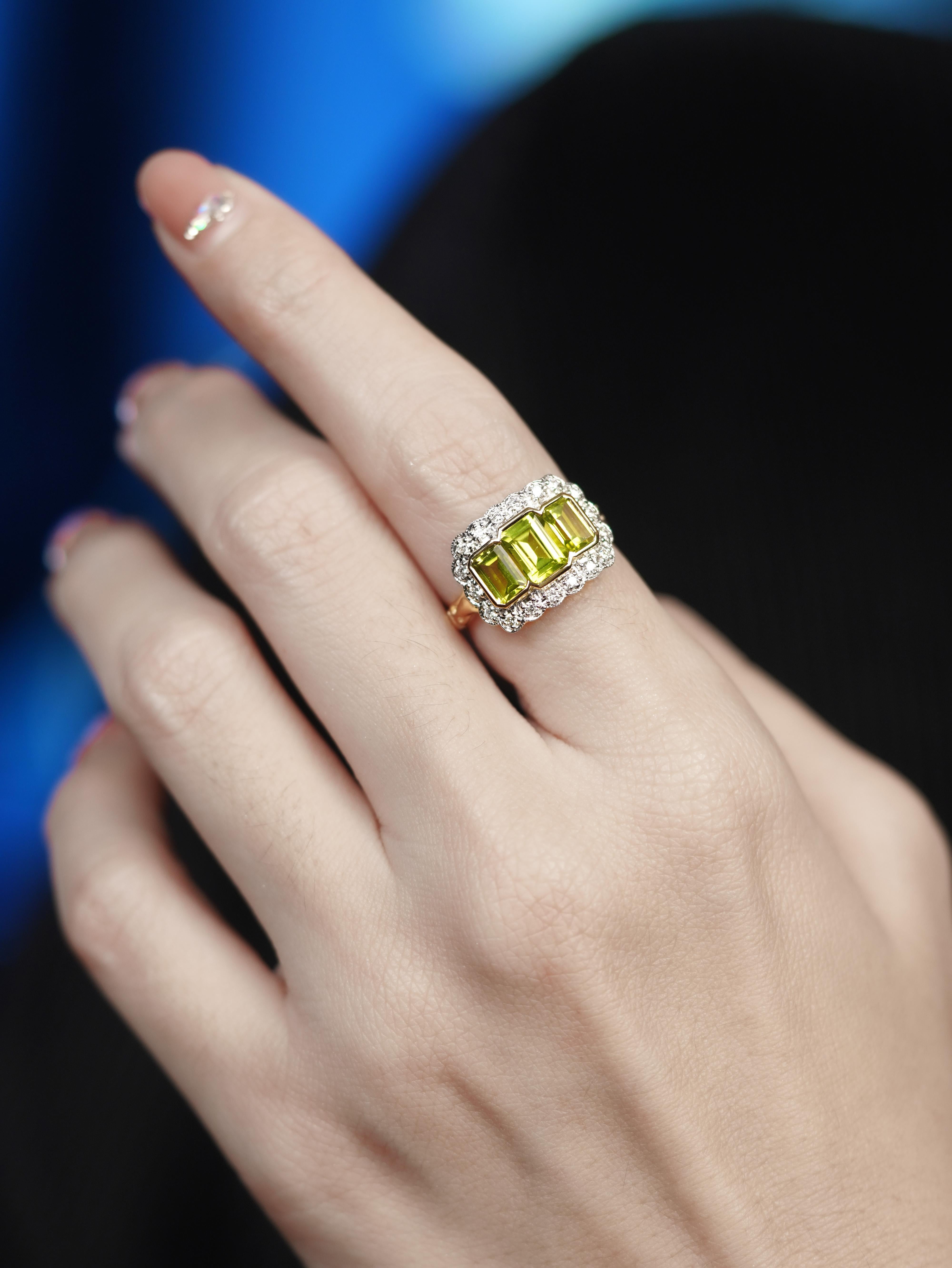 Mélange captivant de couleurs et d'éclat, cette bague antique de style Arte Antiques rayonne d'un charme intemporel. Trois péridots vibrants occupent le devant de la scène, chacun encadré gracieusement par des diamants étincelants. La disposition