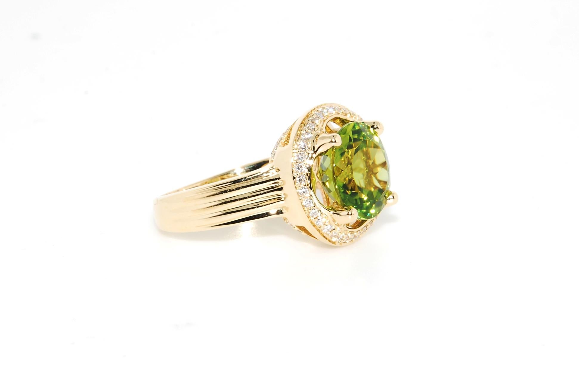 A 1.66 carat round faceted Peridot with .26 carats total weight of round full-cut diamonds set in 14 karat yellow gold. A basic,sleek, and elegant contemporary design. The Peridot is fine quality. Very nicely finished in the under gallery with a