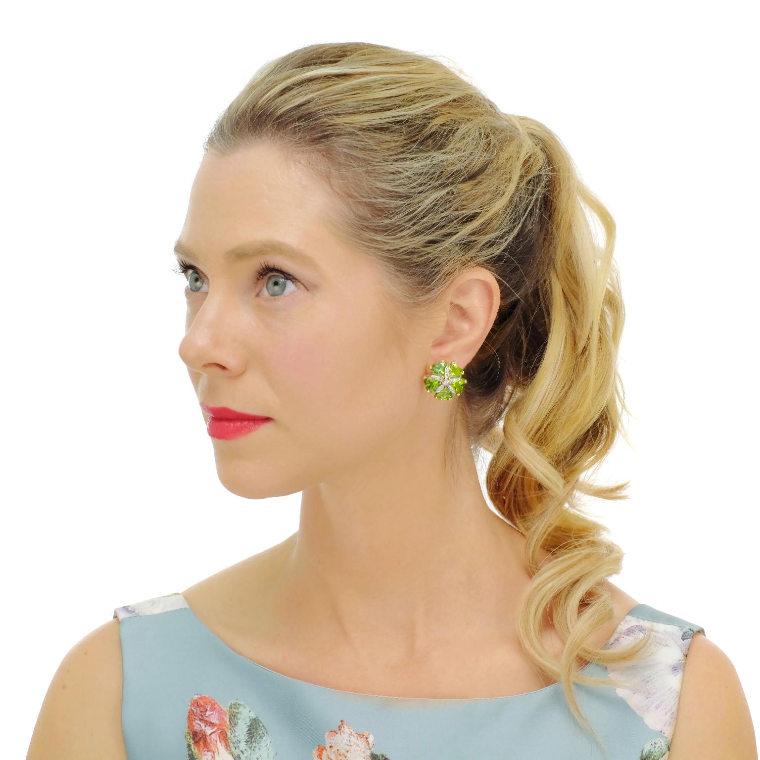 Circa 1980s, 18k.   These sophisticated eighties earrings have a fresh visual appeal. The colorful floret motif, in vibrant peridot with diamond-set centers, is elegantly colorful. The look effortlessly dresses up or down. Finely fabricated, the 10