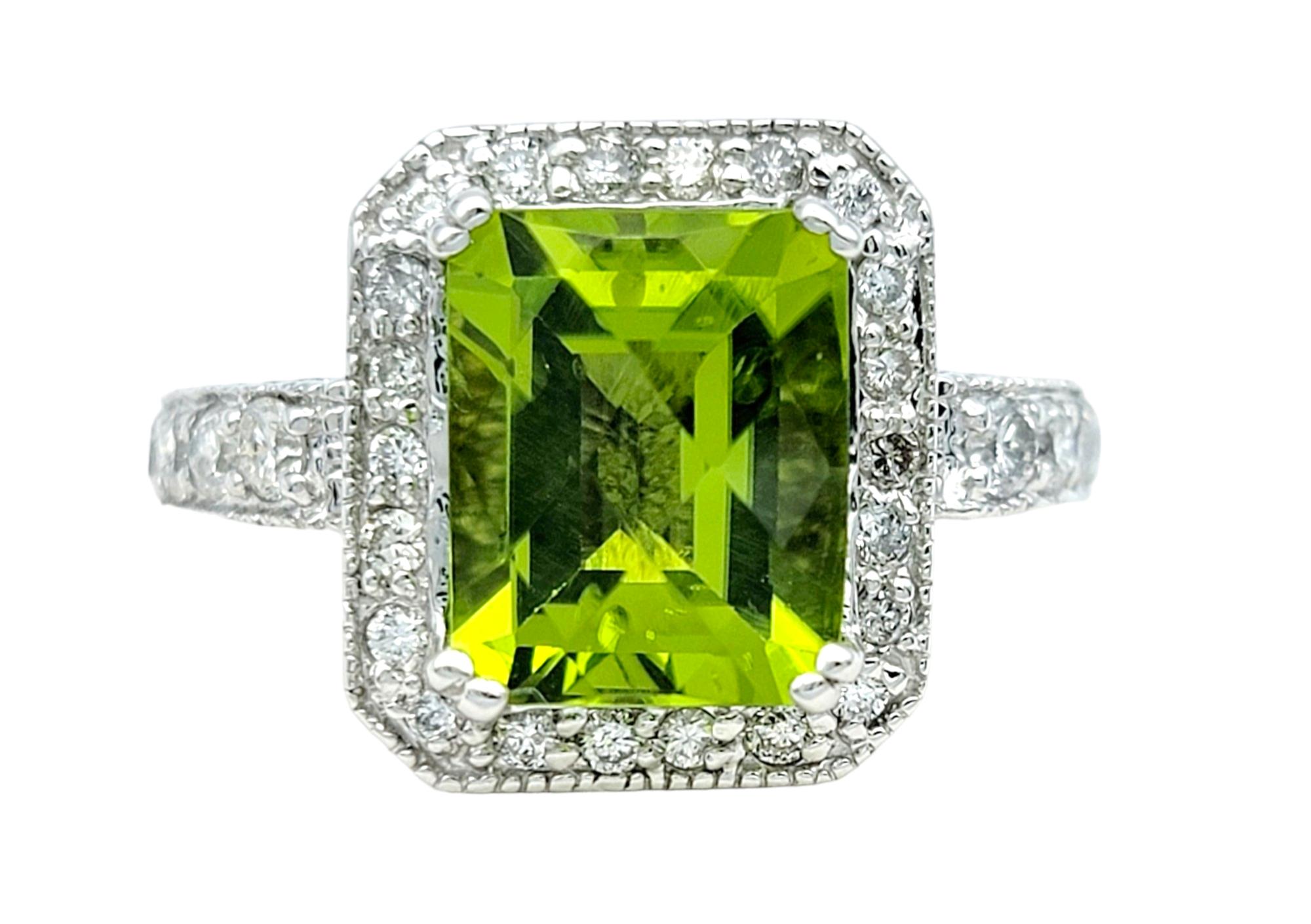 Ring Size: 6.75

This exquisite ring features a mesmerizing cut-cornered rectangular checkerboard peridot as its focal point, exuding a captivating green hue that symbolizes vitality and renewal. Surrounded by a sparkling halo of diamonds, the