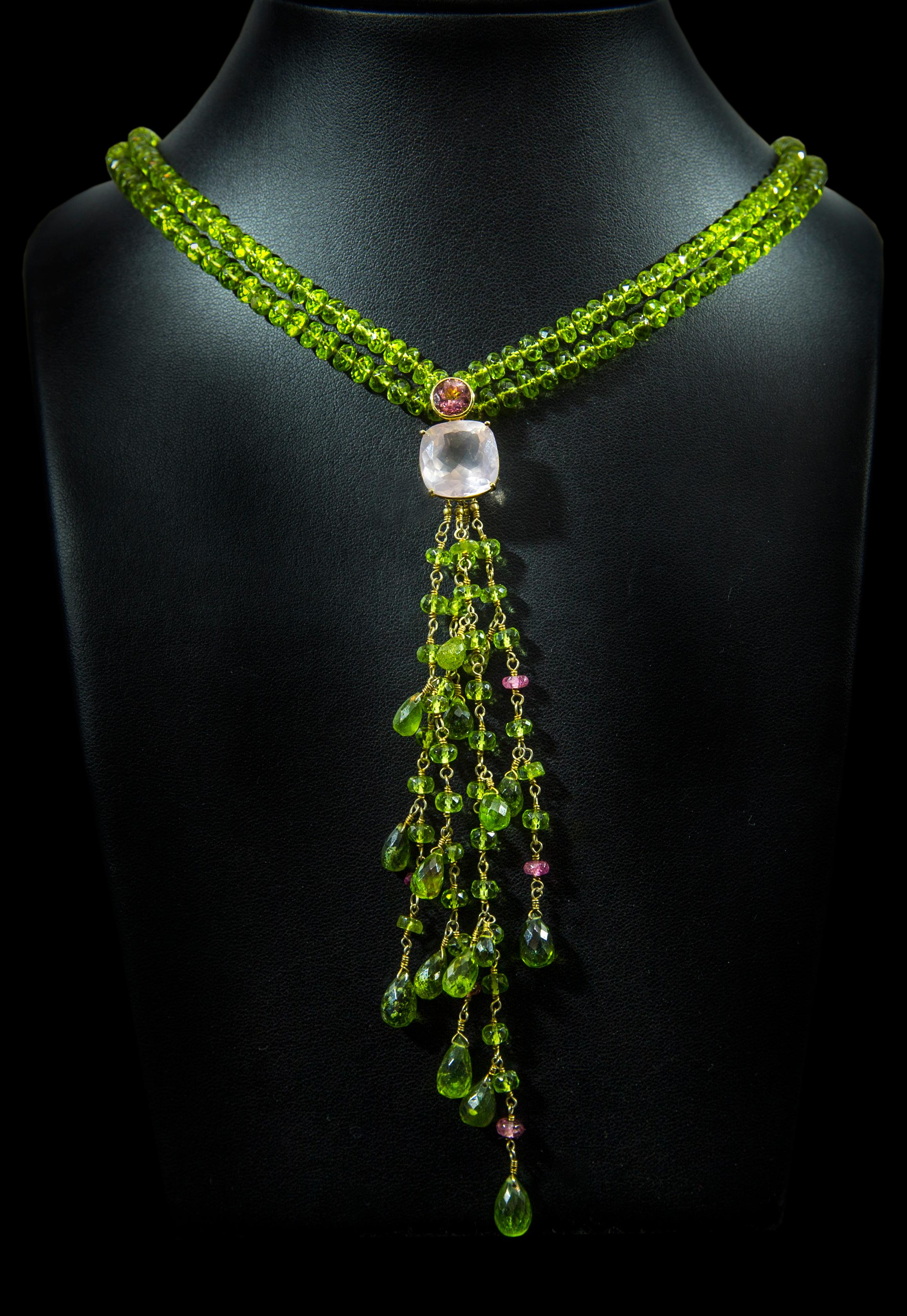 This Jane Magon Collections necklace is from the Warrior Woman Collection and has a Lariat Style with an organic feel. Gem Quality Peridot Beads that come to a Tendril of Peridot, Pink Tourmaline beads with a Round Pink Tourmaline, and a Square