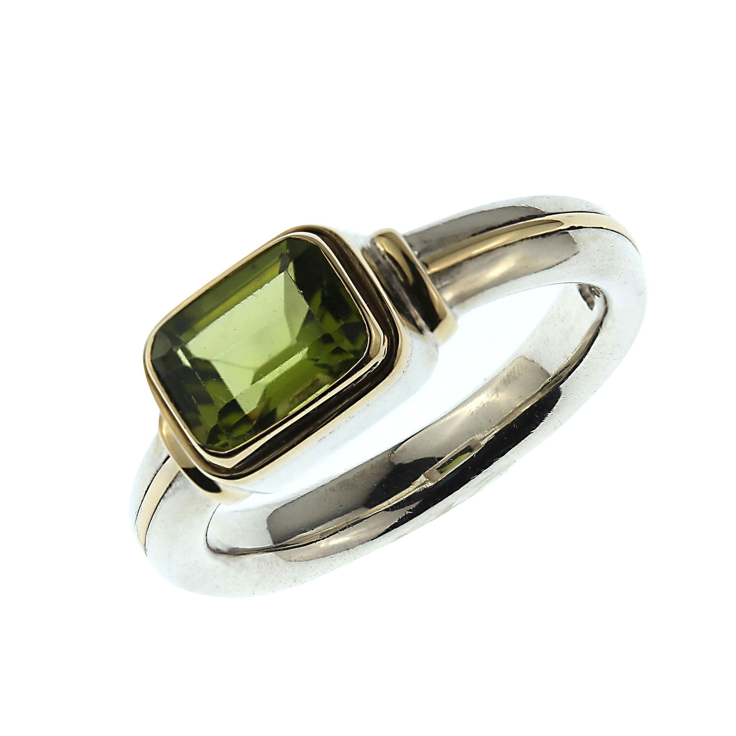 Sparkling step cut Peridot set east-west in an 18K Yellow Gold Bezel atop a comfort fit Sterling Silver Ring.  This lovely ring is such a pleasure to slide onto your finger. Follow the 18K Gold line around the shank  from one side of the head to the