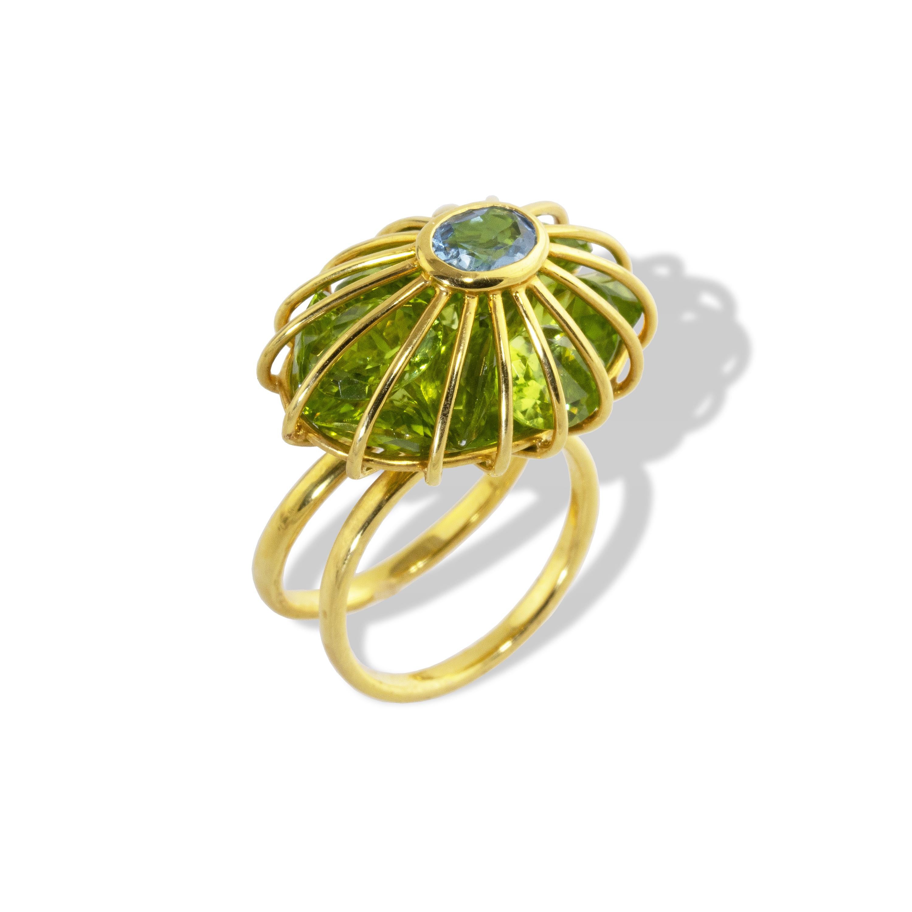 Peridot Cage ring set with loose peridot gemstones and topped with an Aquamarine. 
Filled with 17.73 carats of Peridot and topped with a 2.5carat Santa Maria Aquamarine, known for its deep, rich color.  Stones are loose inside so they catch the