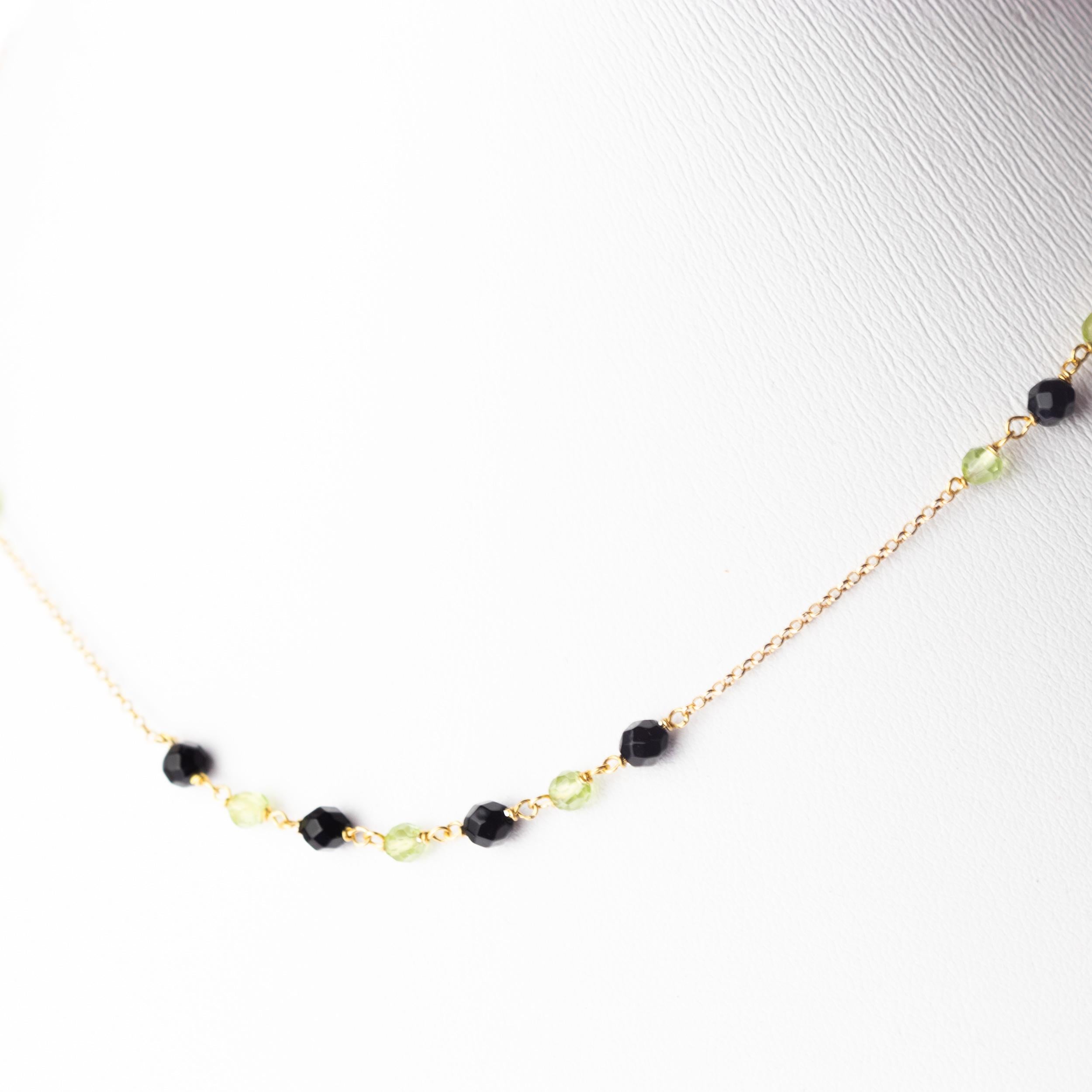 Marvellous necklace starring natural peridot and black agate spheres, for a bright charm of uniqueness. Luminous jewel with natural precious jewellery on elegant 18 karat yellow gold chain. 
 
Peridot is a popular stone for protection against