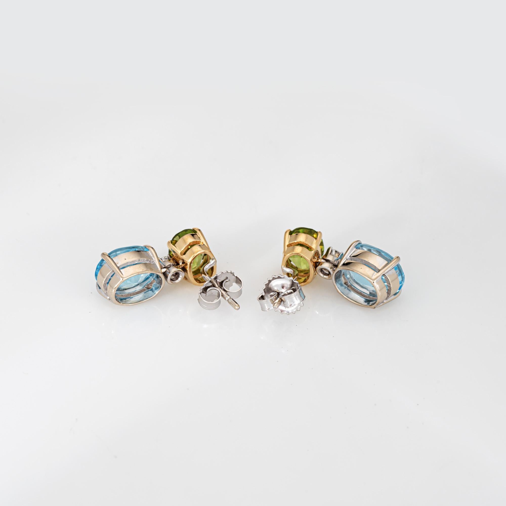 Stylish peridot, blue topaz & diamond drop earrings crafted in 18k yellow & white gold.

Peridot measures 8mm x 6mm and blue topaz measures 10mm x 8mm. Two diamonds total an estimated 0.10 carats (estimated at H-I color and SI2-I1 clarity). Note: