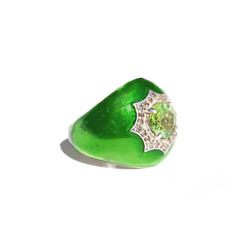 Bague Bomba à péridot et diamant en émail présentant un péridot vert chartreuse lumineux dans un groupe de diamants sertis dans un design Bomba avec un intérieur concave et une élégante finition en émail vert métallisé brillant.

- Péridot vert