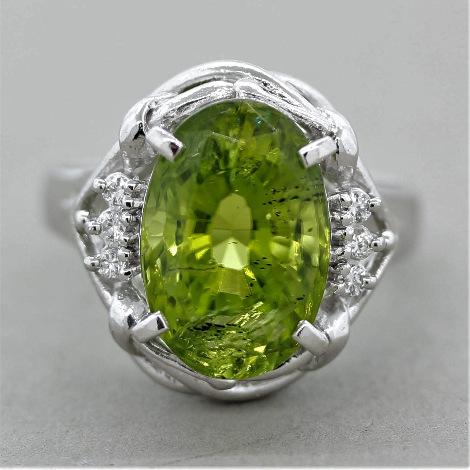 A platinum ring featuring a luscious 6.44 carat peridot. The oval shaped gem is accented by 6 round brilliant-cut diamonds weighing a total of 0.07 carats. Hand fabricated in platinum.

Ring Size 6.50